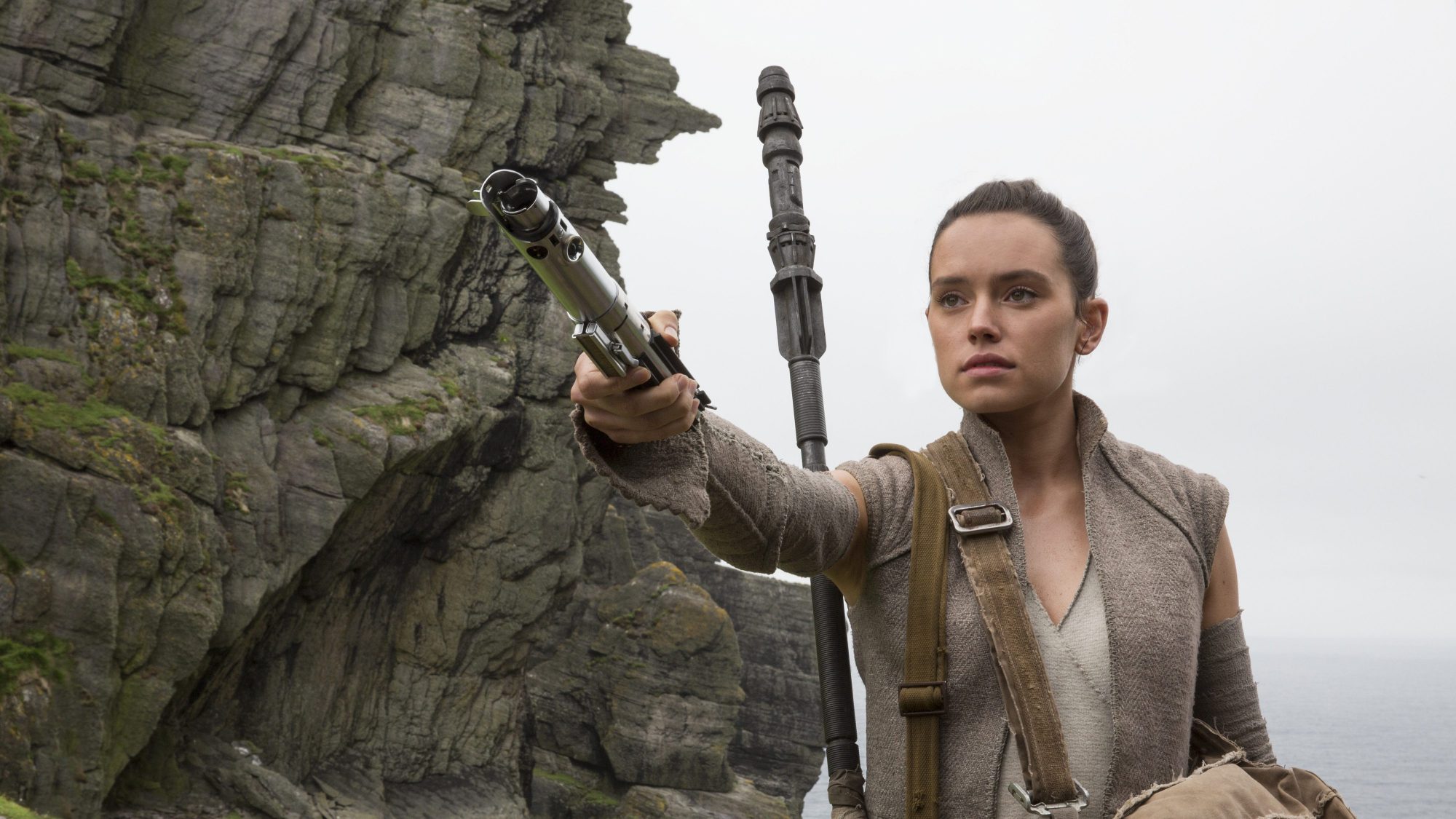 Rey from Star Wars holding a lightsaber HD Wallpaper