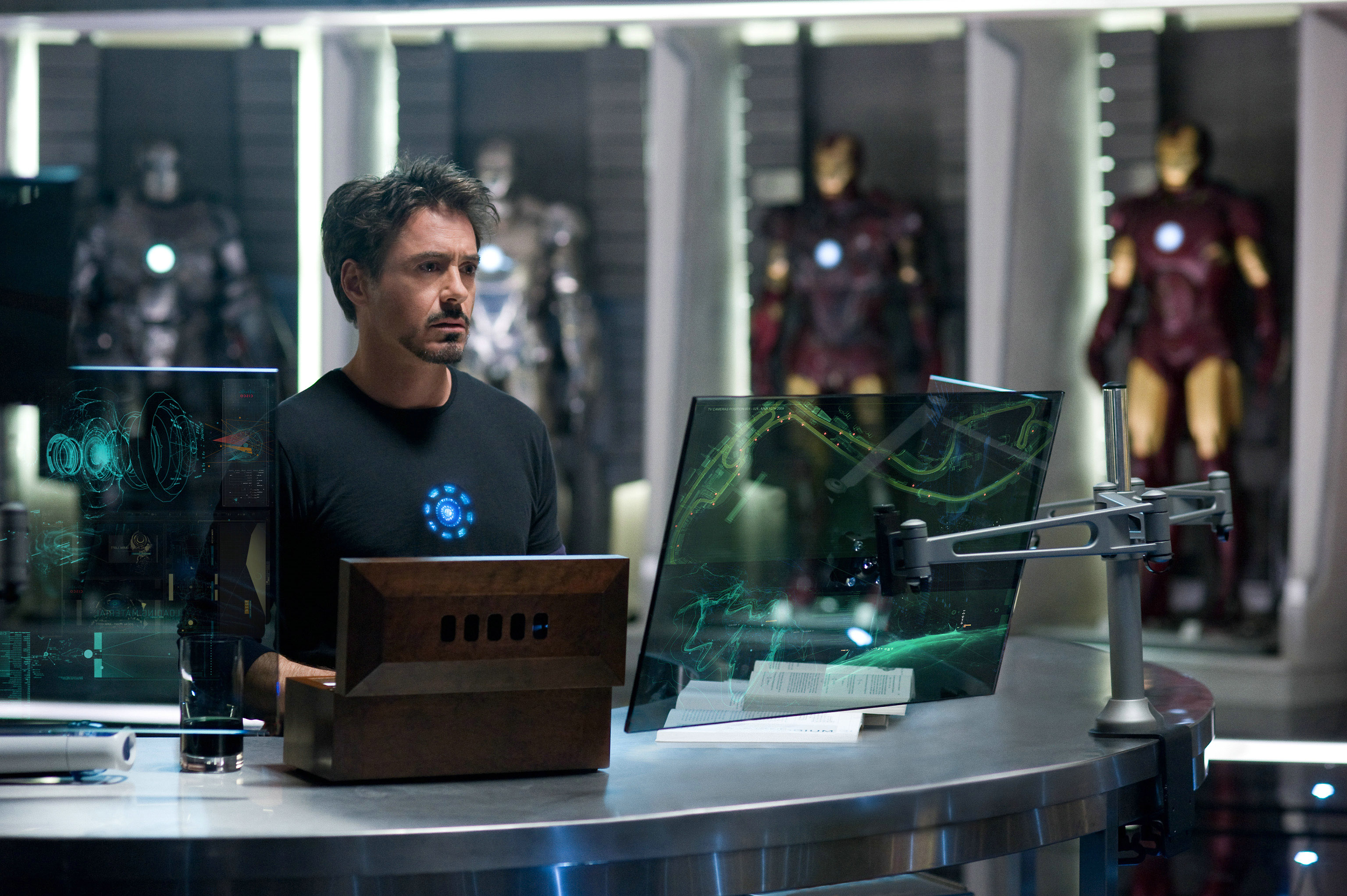 Tony Stark in his workshop with Iron Man suits HD Wallpaper