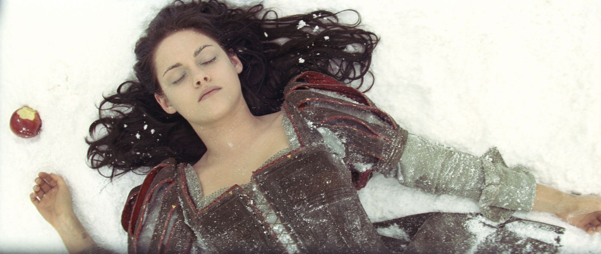 Snow White lying in snow with an apple HD Wallpaper