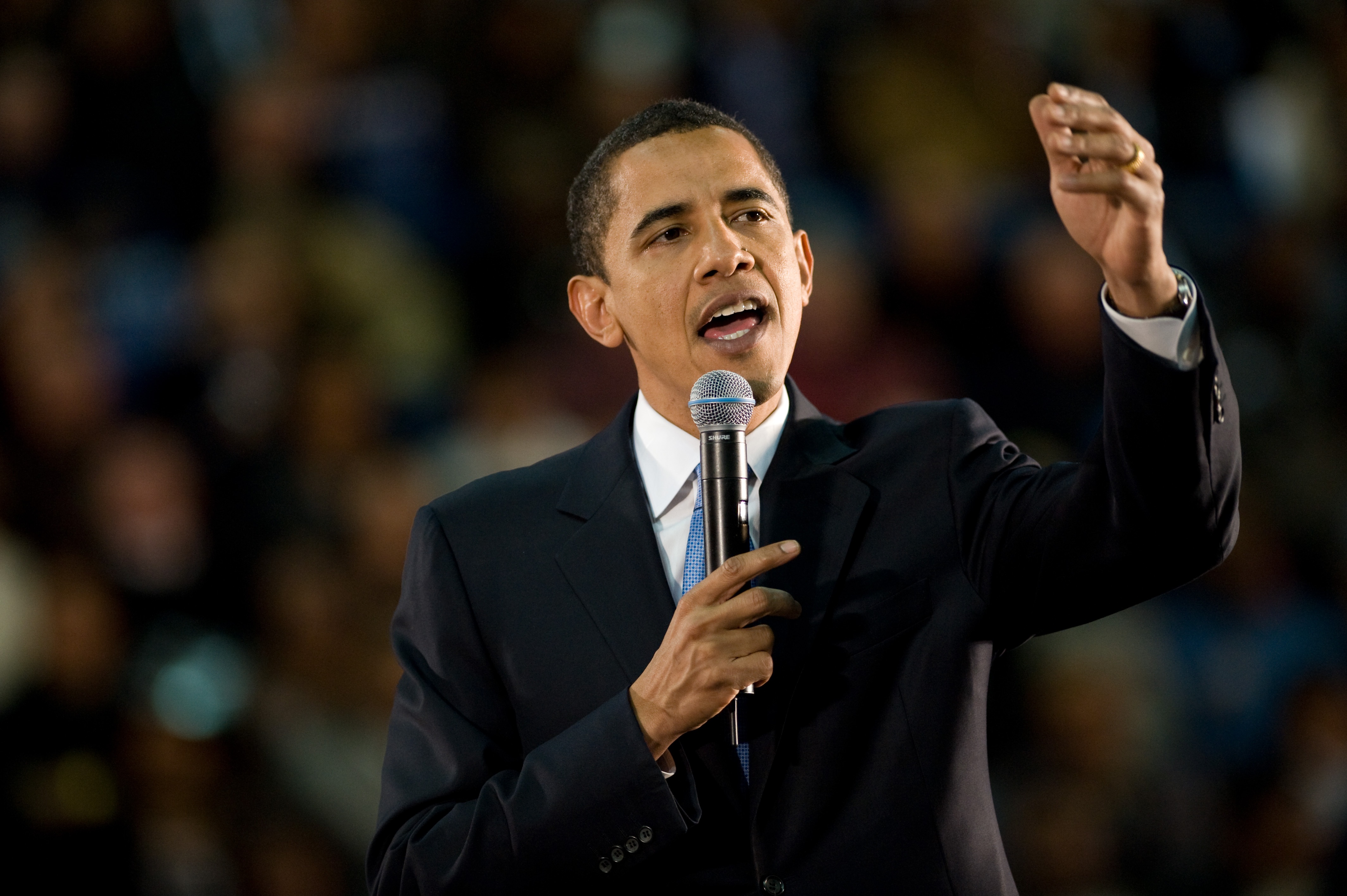 Barack Obama speaking at a podium HD Wallpaper