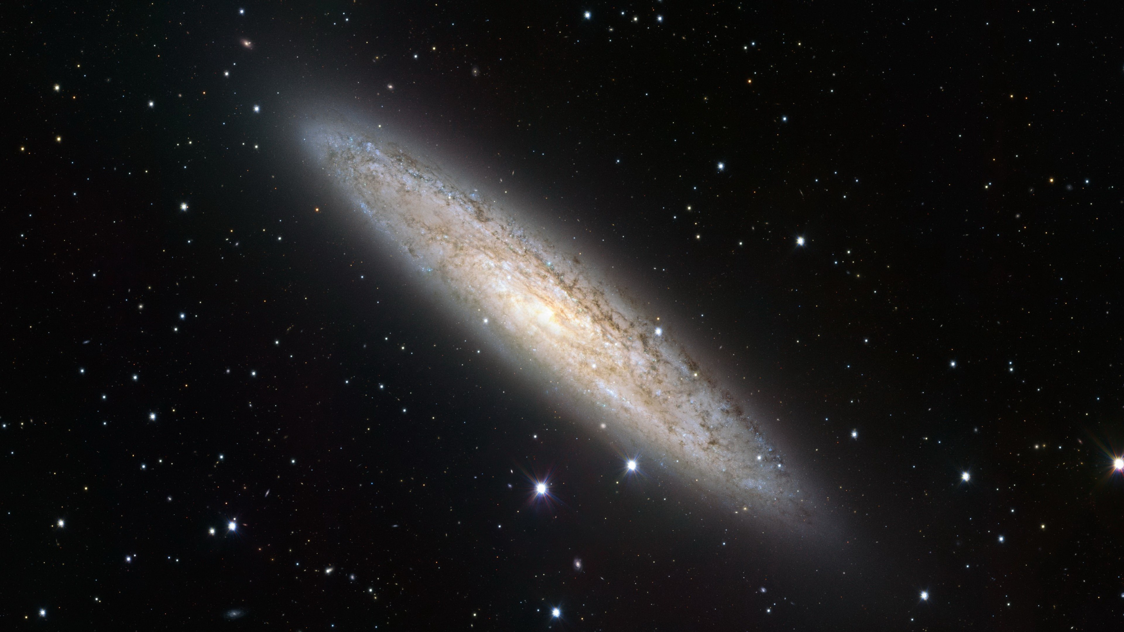 Edge-on spiral galaxy with surrounding stars HD Wallpaper