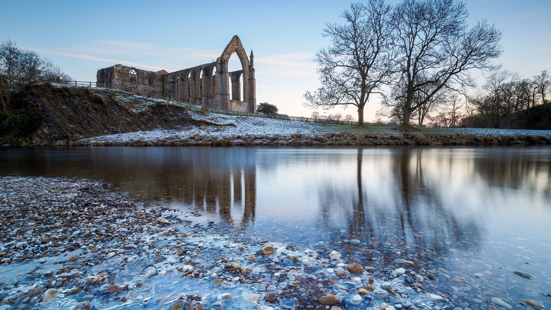 Snow-Dusted Ruins by a Calm Winter Lake HD Wallpaper
