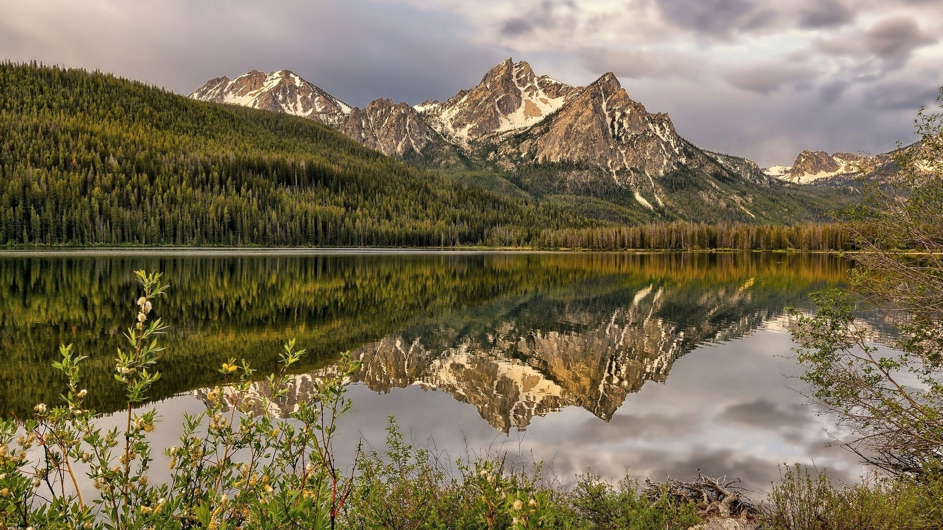 Snow-capped mountains reflected in a calm lake HD Wallpaper