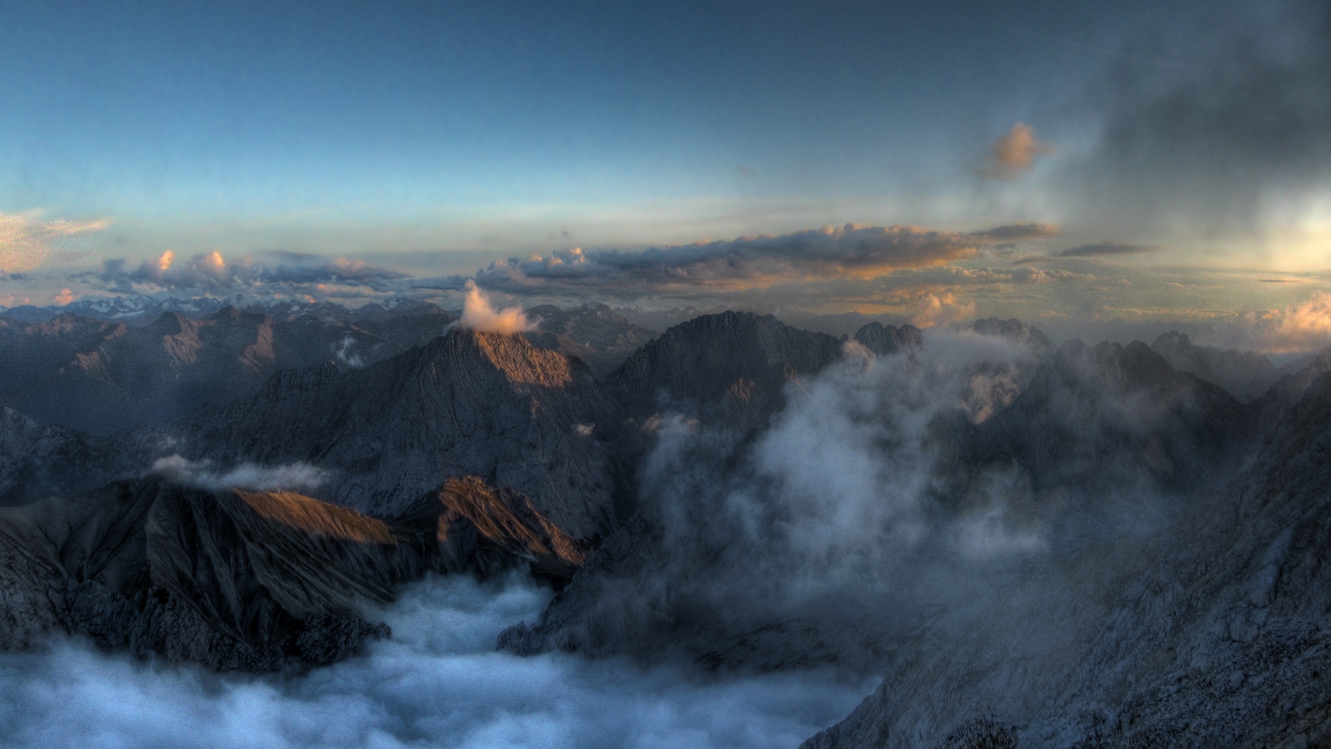 Mountain tops shrouded in mist at sunset HD Wallpaper
