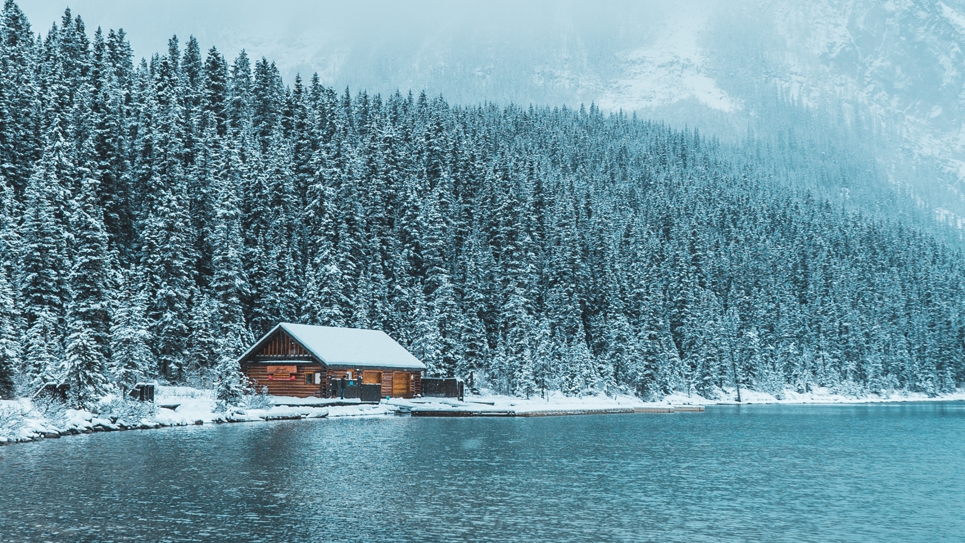 Log cabin by a lake in a snowy forest HD Wallpaper