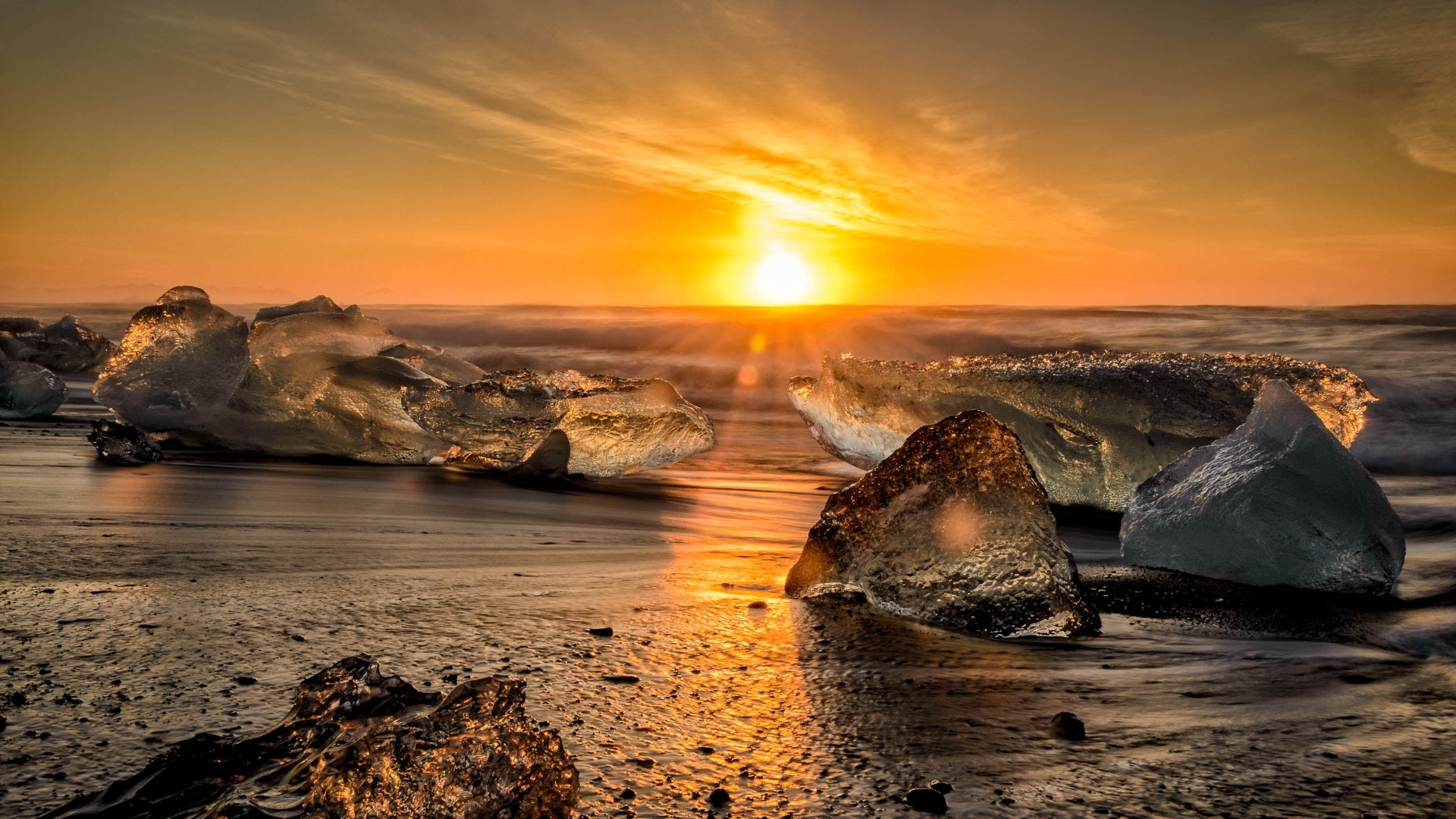 Ice chunks on a beach at sunset HD Wallpaper