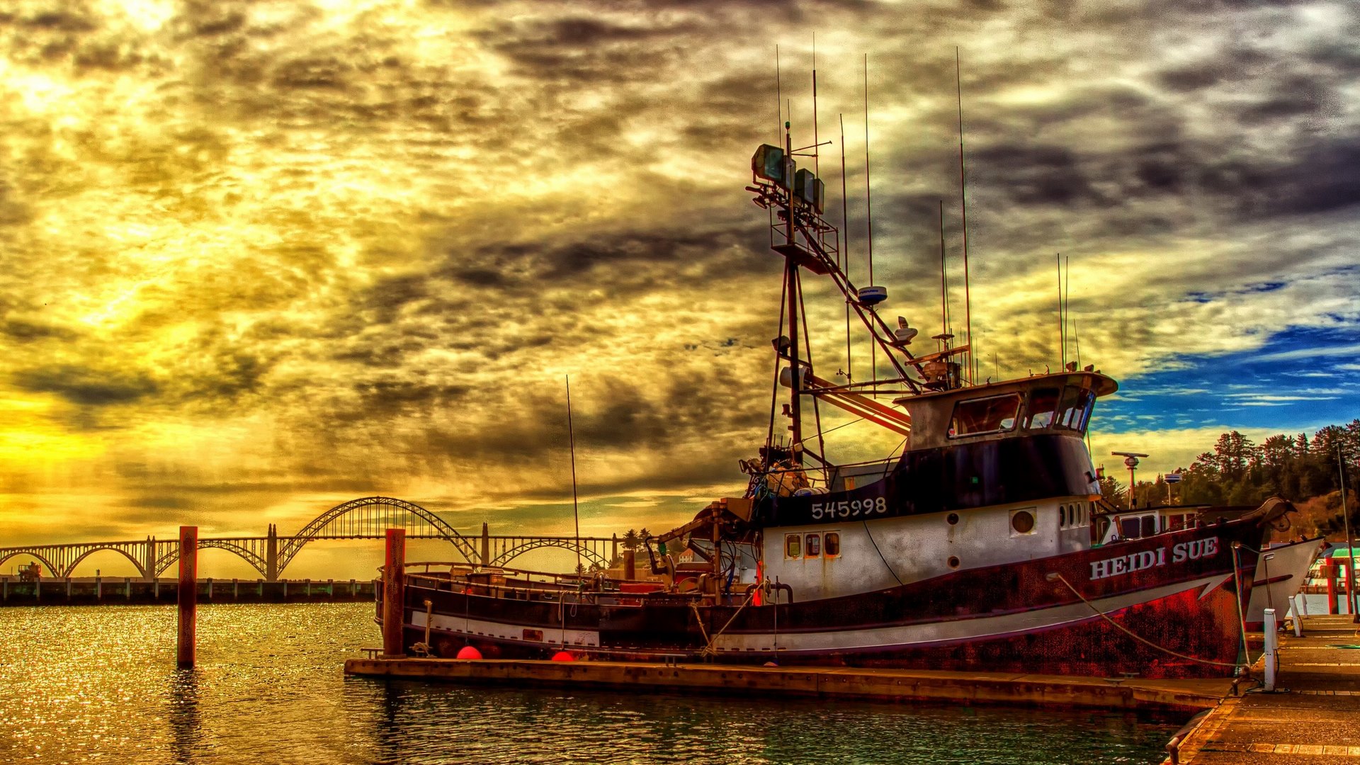 Fishing boat Heidi Sue docked near a bridge at sunset HD Wallpaper