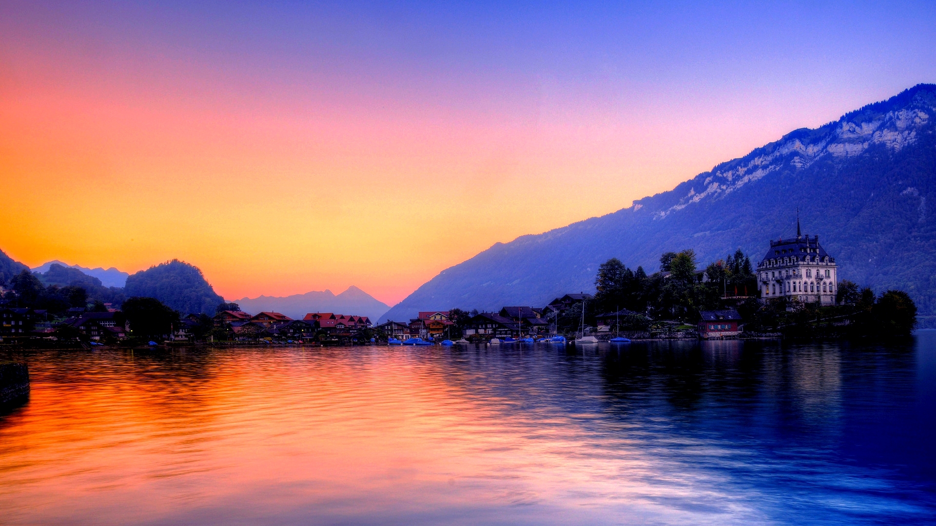 Lake with mountains and village at sunset HD Wallpaper