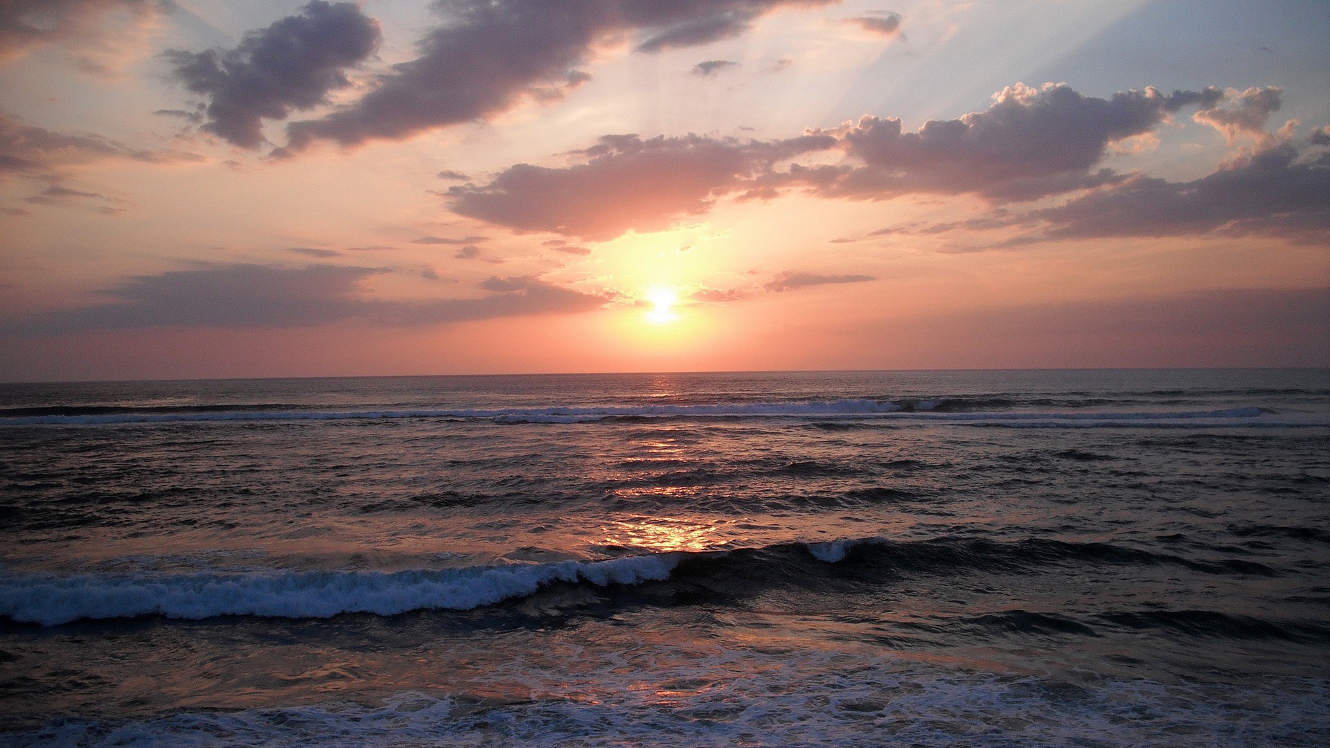 Sunset over the ocean with waves and clouds HD Wallpaper