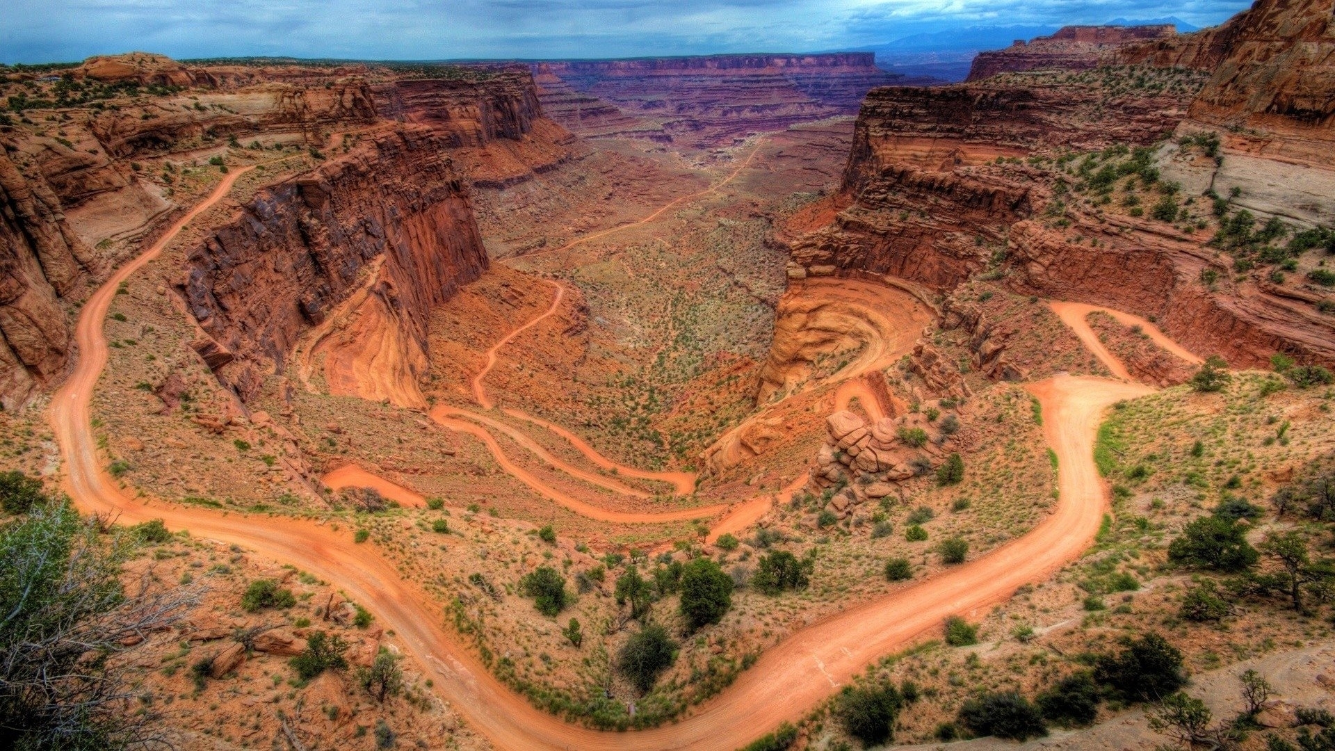 Dirt road winding through a desert canyon HD Wallpaper