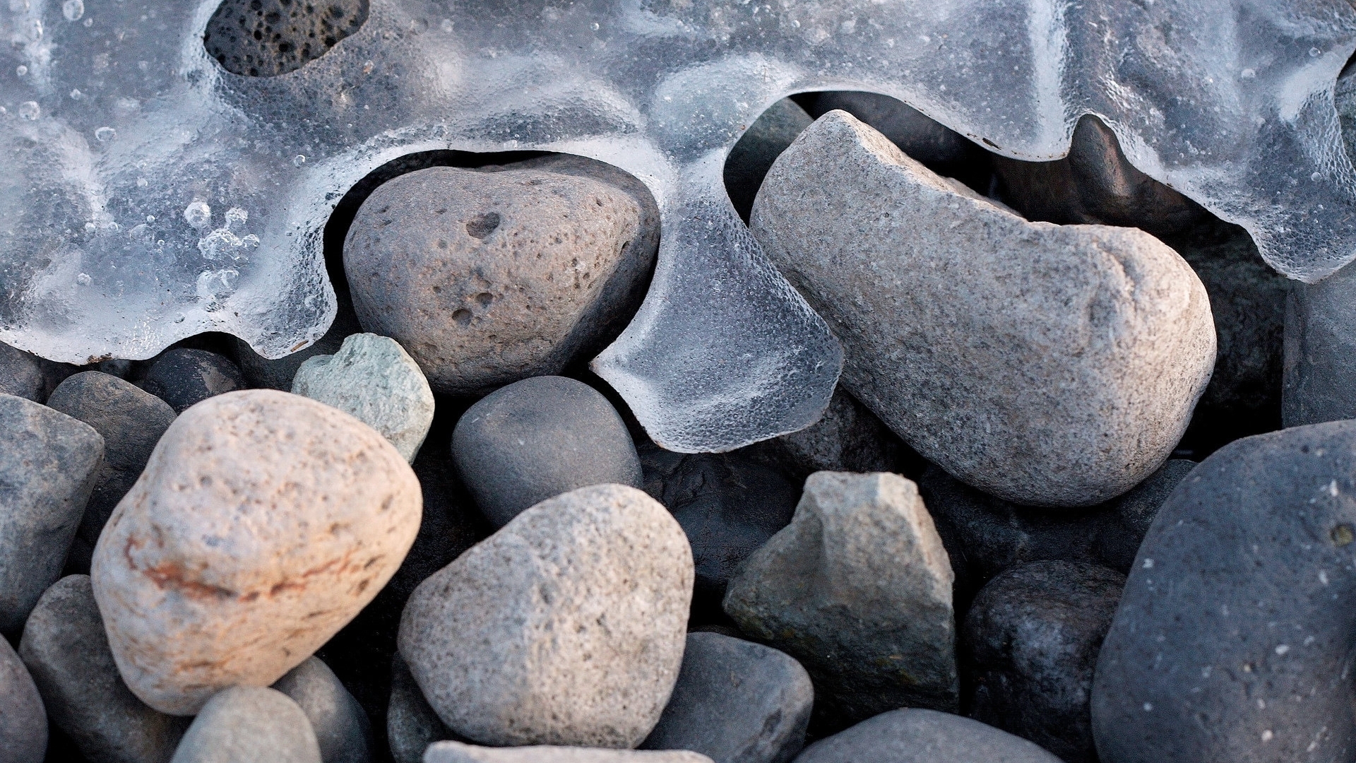 Ice and rocks on a beach HD Wallpaper