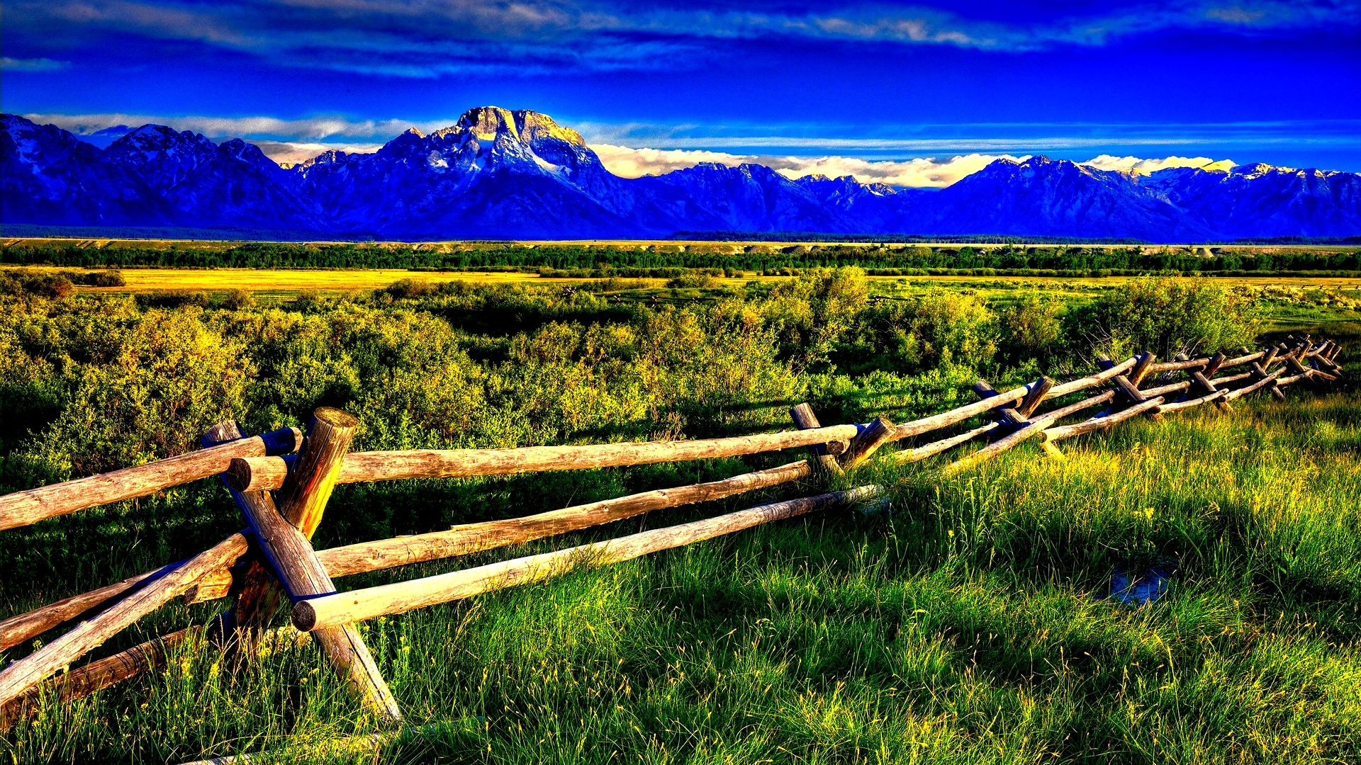 Wooden fence in a field with mountains HD Wallpaper
