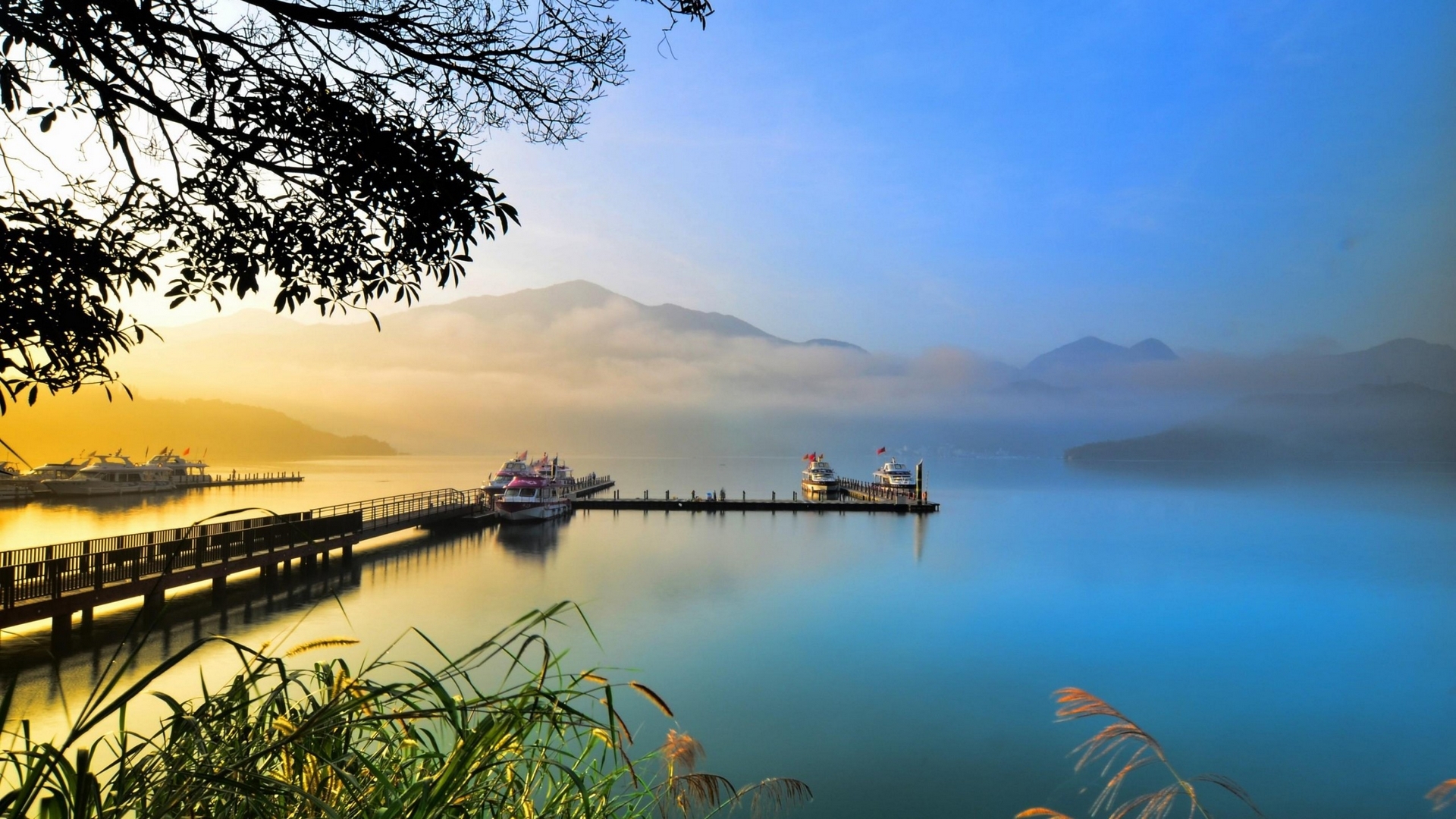 Boats docked at a pier on a misty lake at sunrise HD Wallpaper