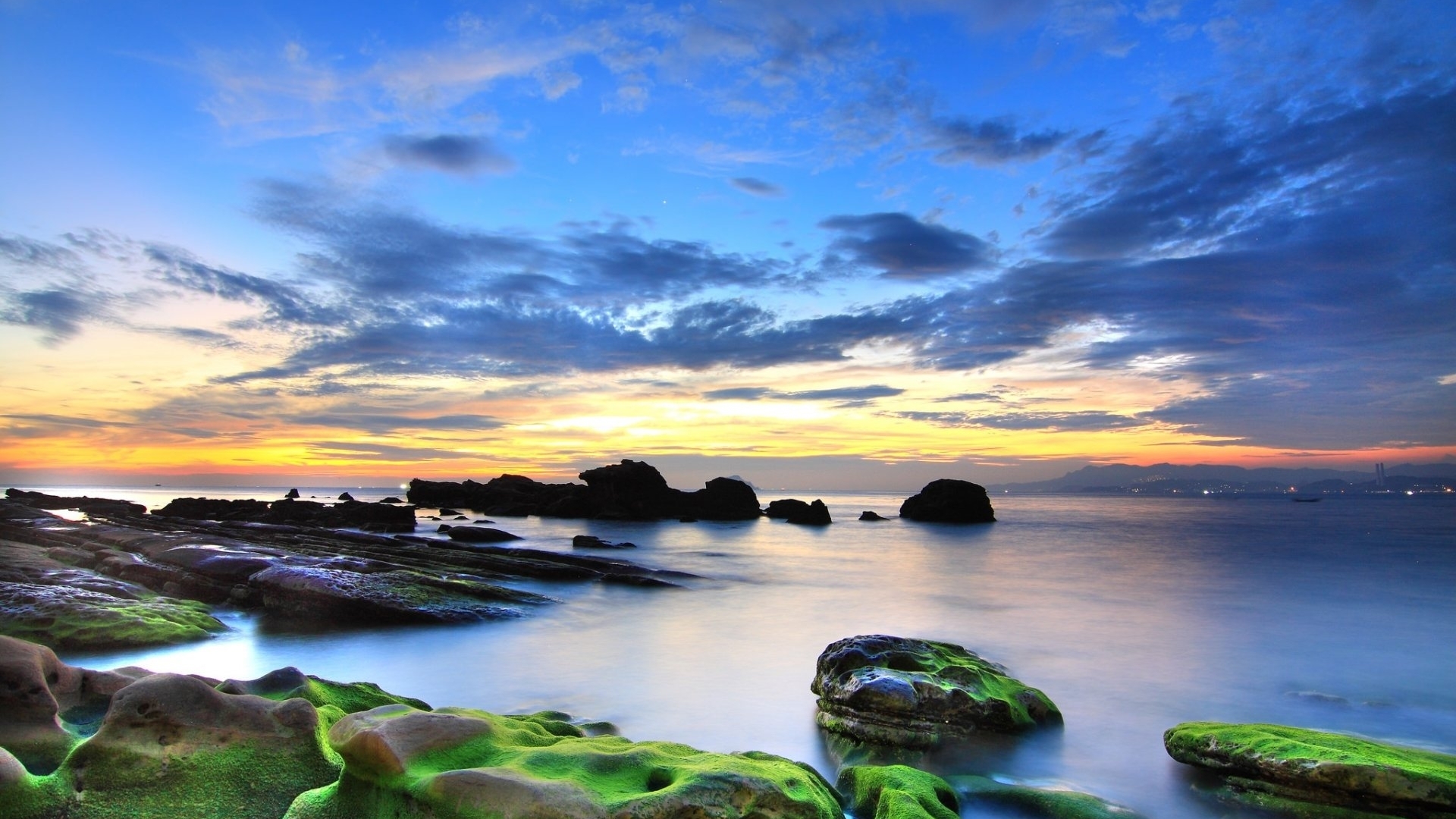 Rocky coast at sunset with ocean and clouds HD Wallpaper