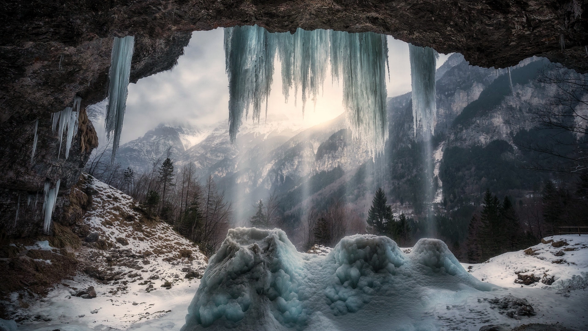 Frozen waterfall in a mountain cave at sunrise HD Wallpaper