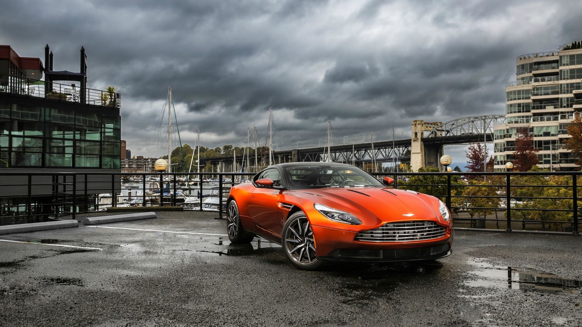 Orange Aston Martin DB11 parked by a marina HD Wallpaper