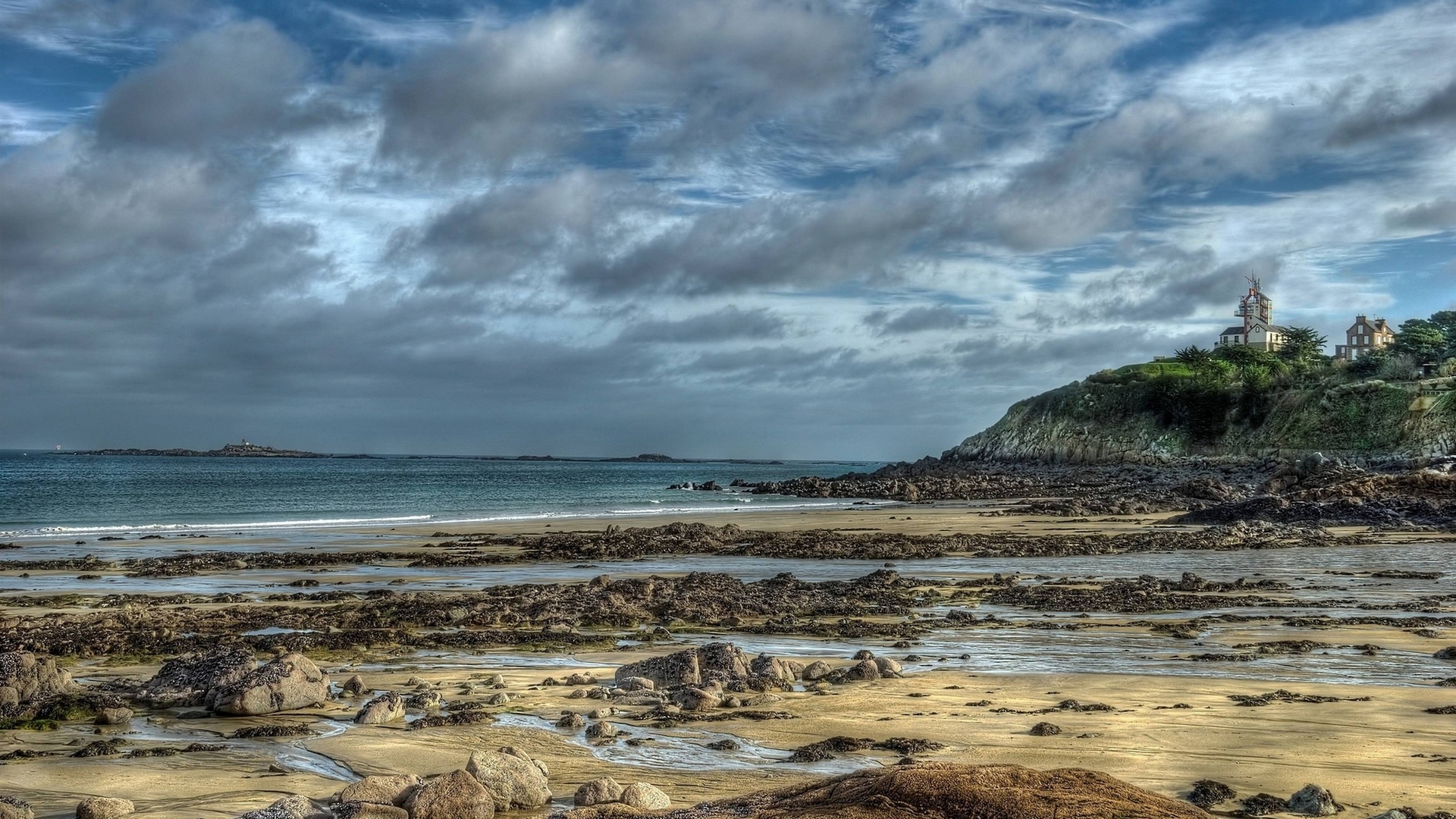 Coastal landscape with lighthouse and rocky beach HD Wallpaper