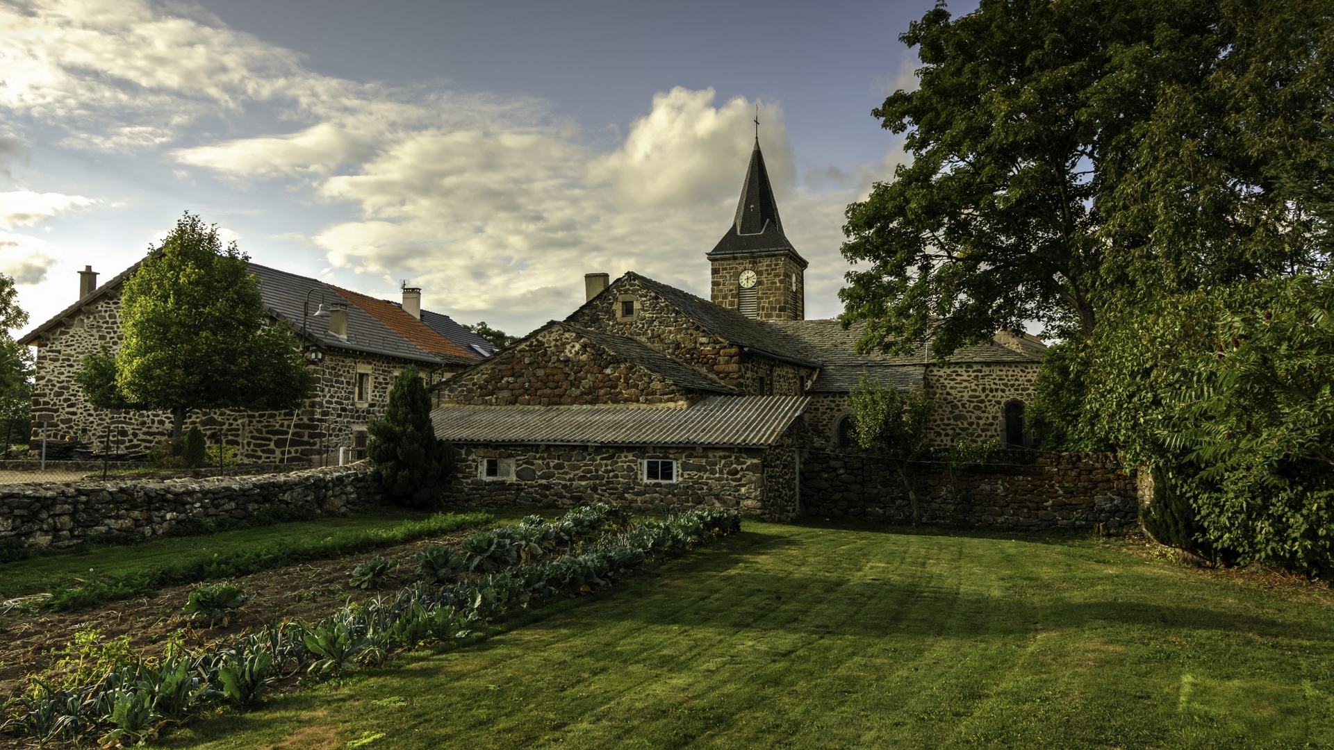 Stone houses and church in a rural French village HD Wallpaper