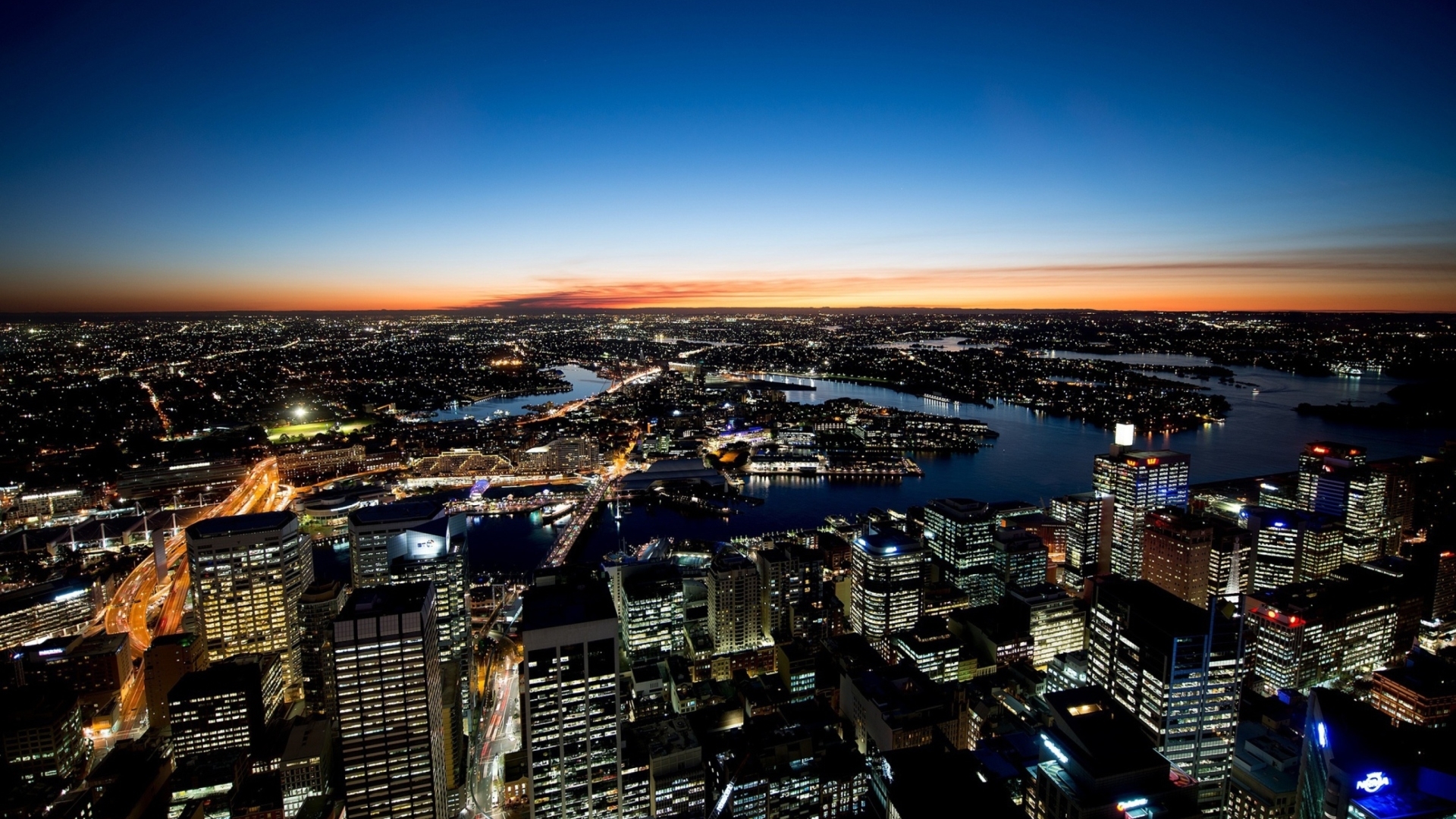 Sydney skyline at dusk with harbor and buildings HD Wallpaper