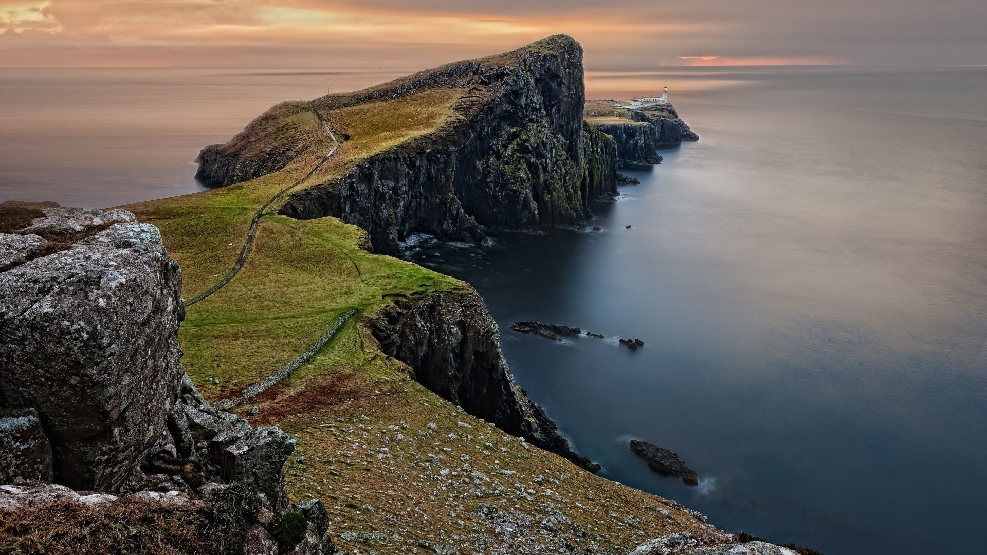 Neist Point Lighthouse on a rocky coast at sunset HD Wallpaper