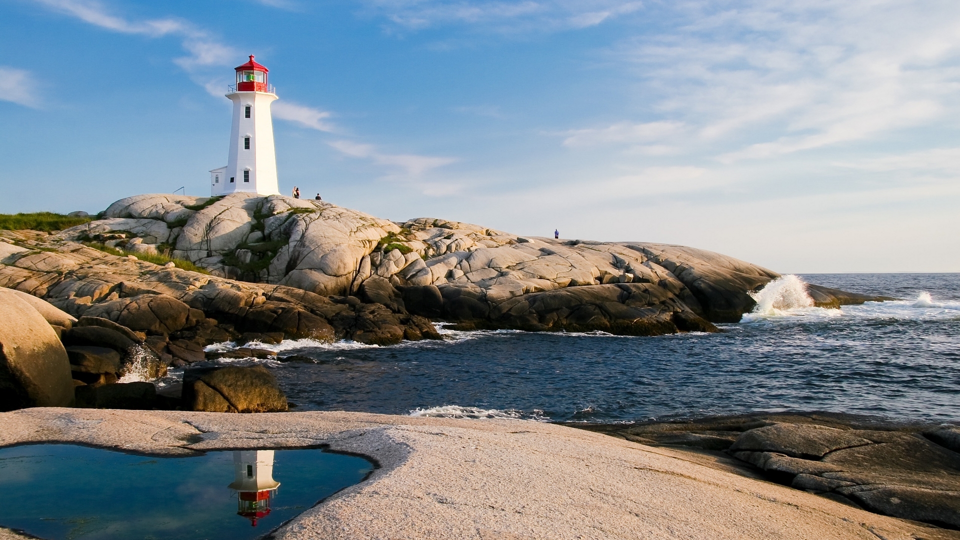 White lighthouse on rocky coast with ocean waves HD Wallpaper