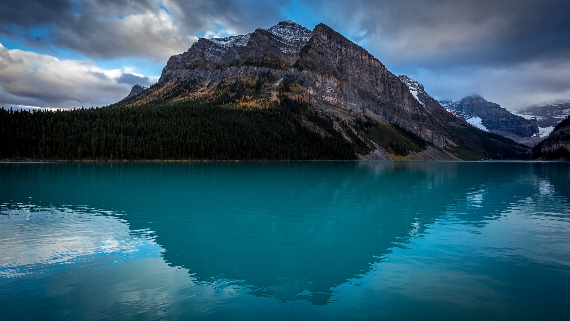 Turquoise lake reflecting mountains and forest HD Wallpaper