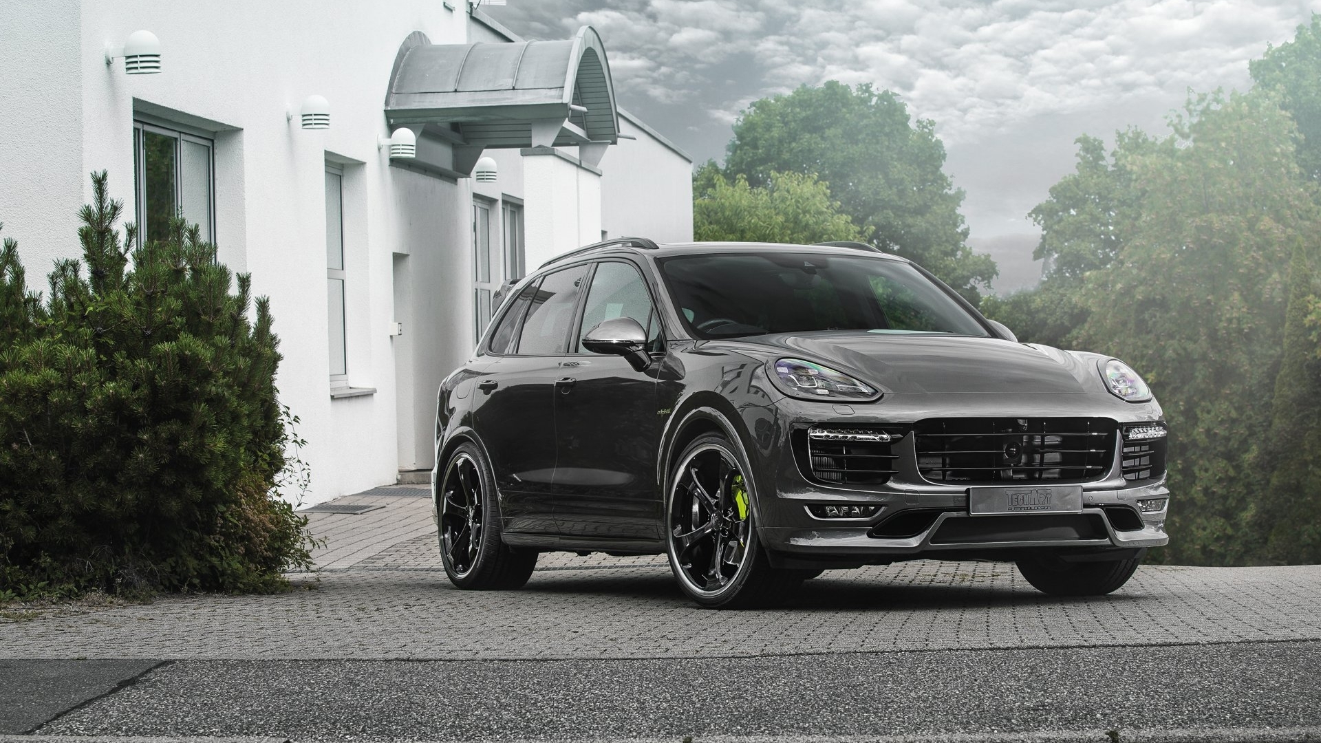 Dark grey Porsche Cayenne parked outside a white building HD Wallpaper
