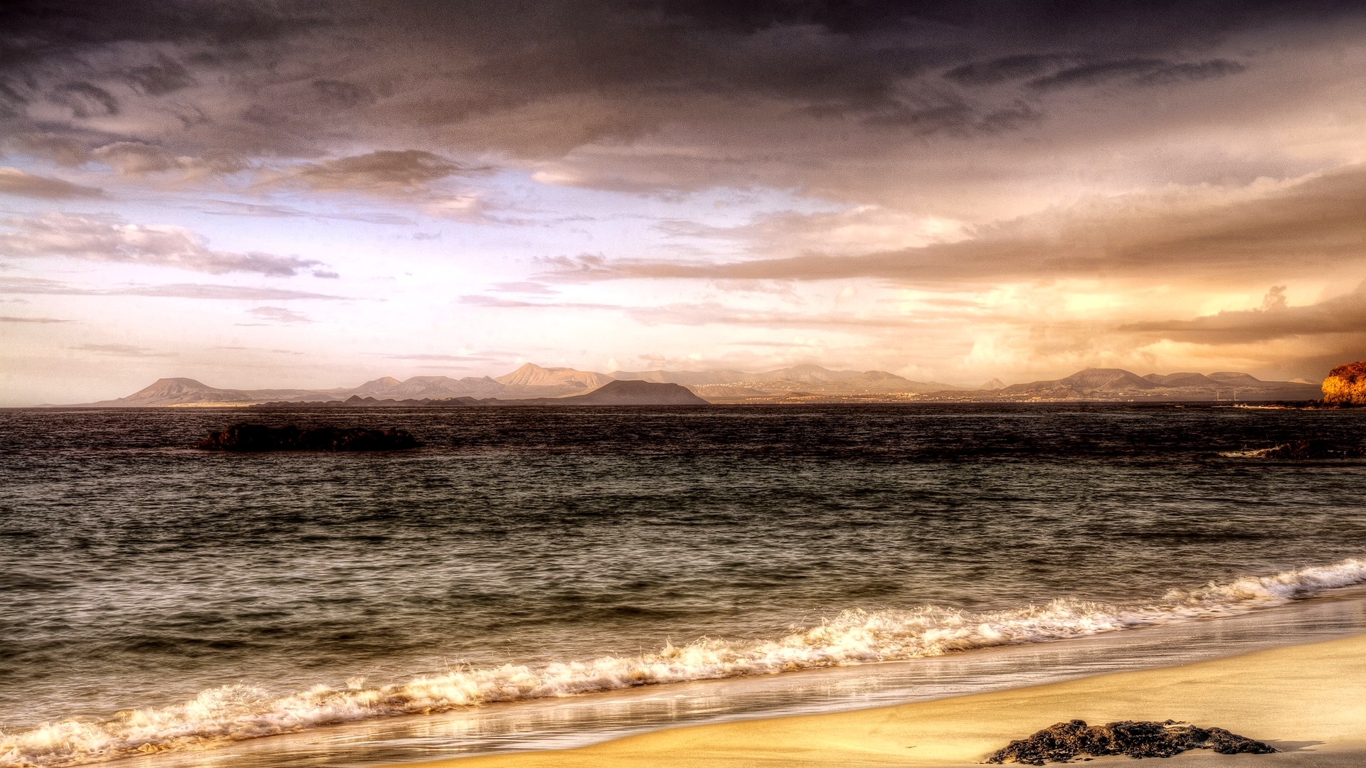Beach with mountains and stormy sky HD Wallpaper