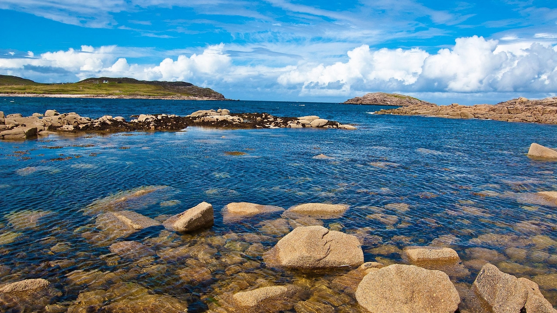Rocky coastline with blue sea and cloudy sky HD Wallpaper