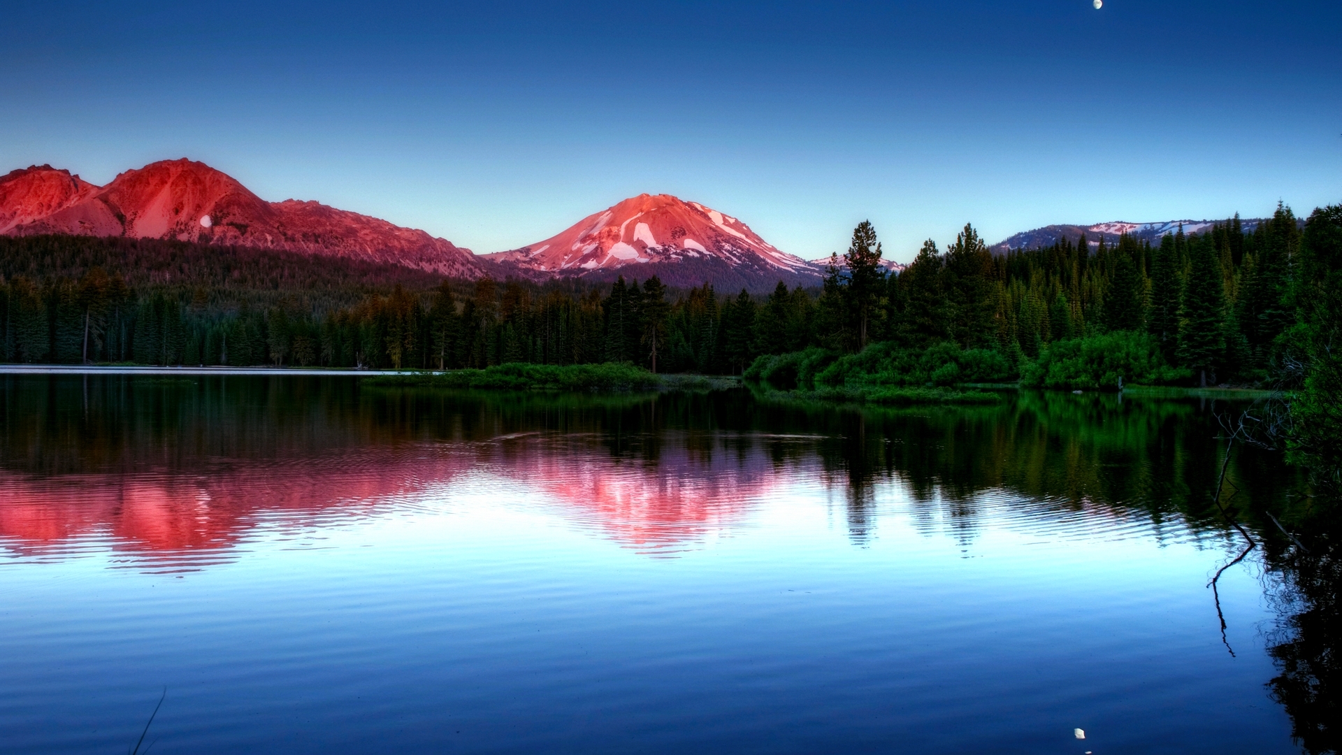 Mountain range reflected in a lake at sunset HD Wallpaper