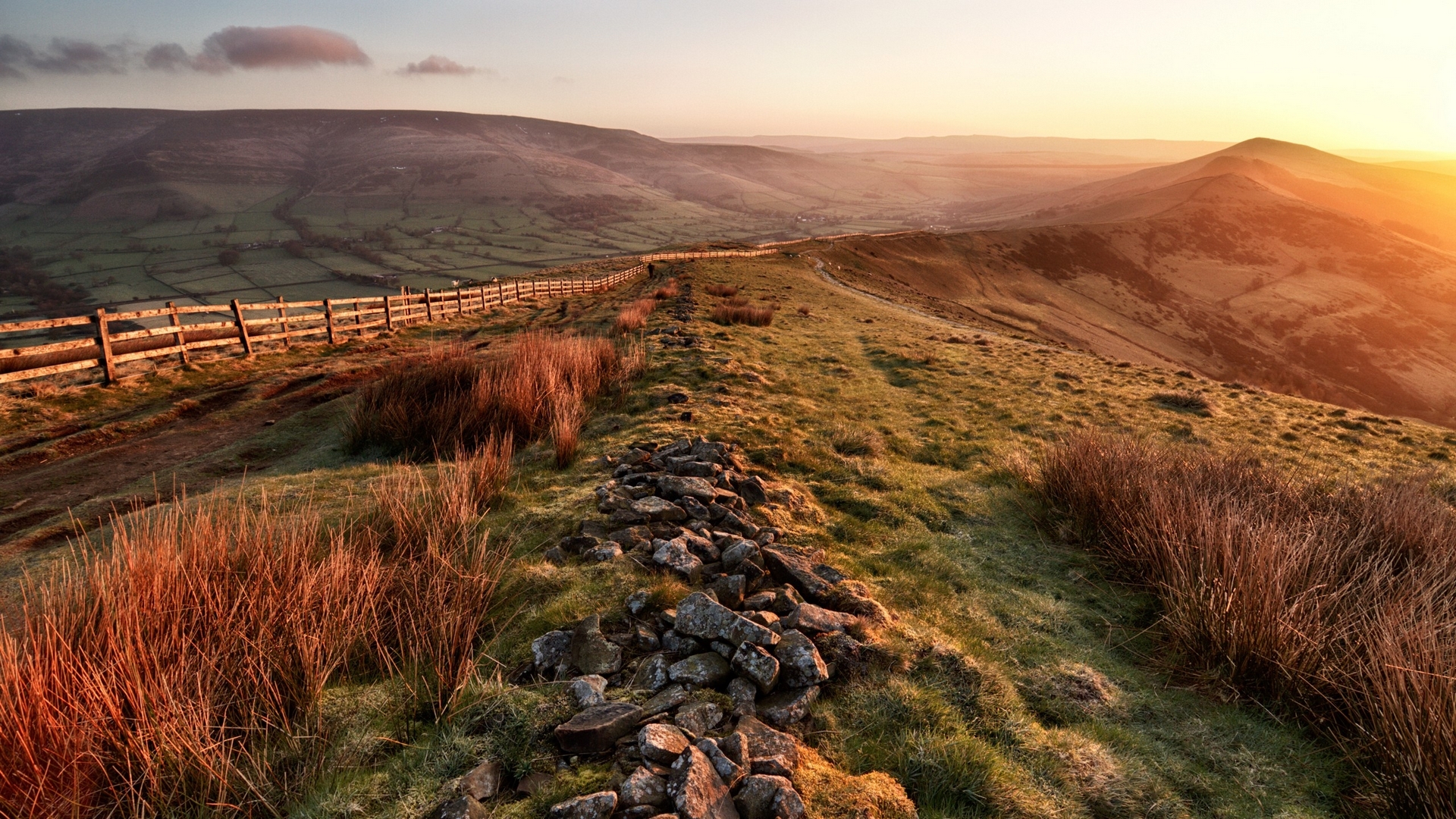 Sunrise over rolling hills with a stone wall and wooden fence HD Wallpaper