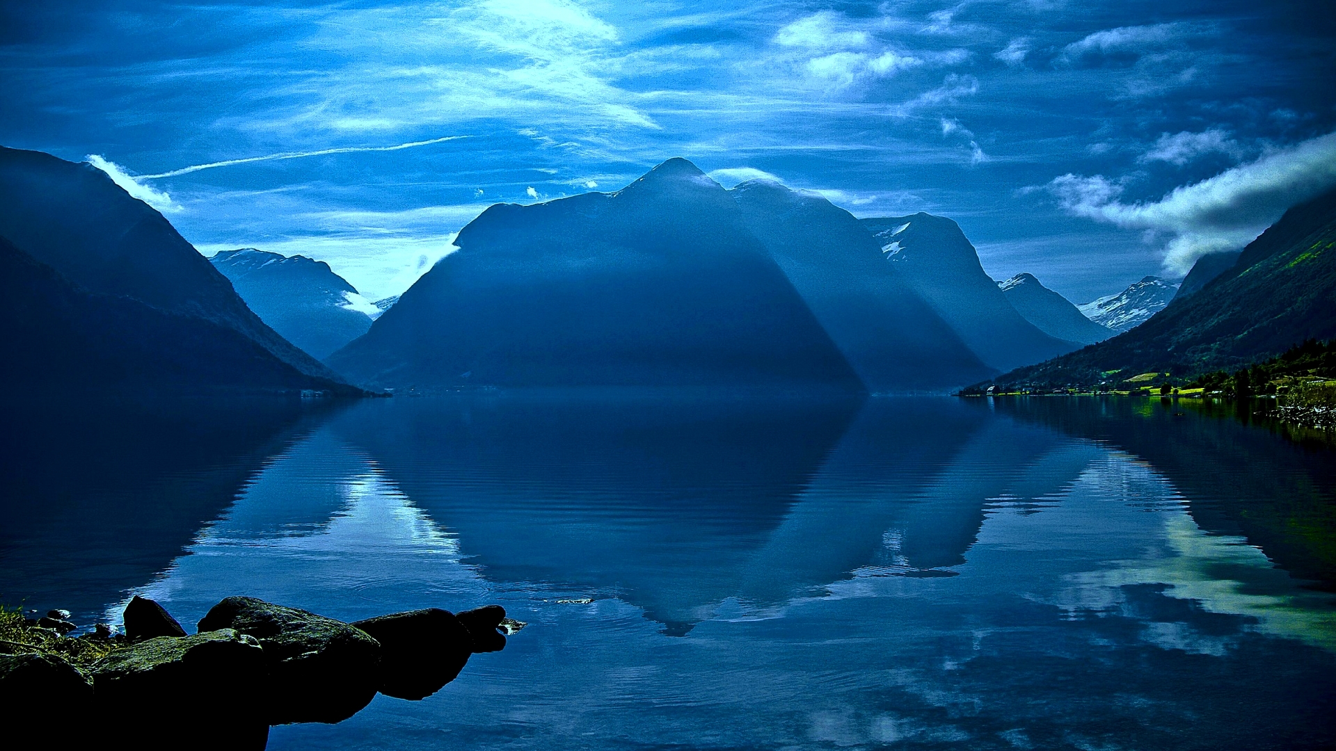Mountains reflected in a lake under a cloudy sky HD Wallpaper