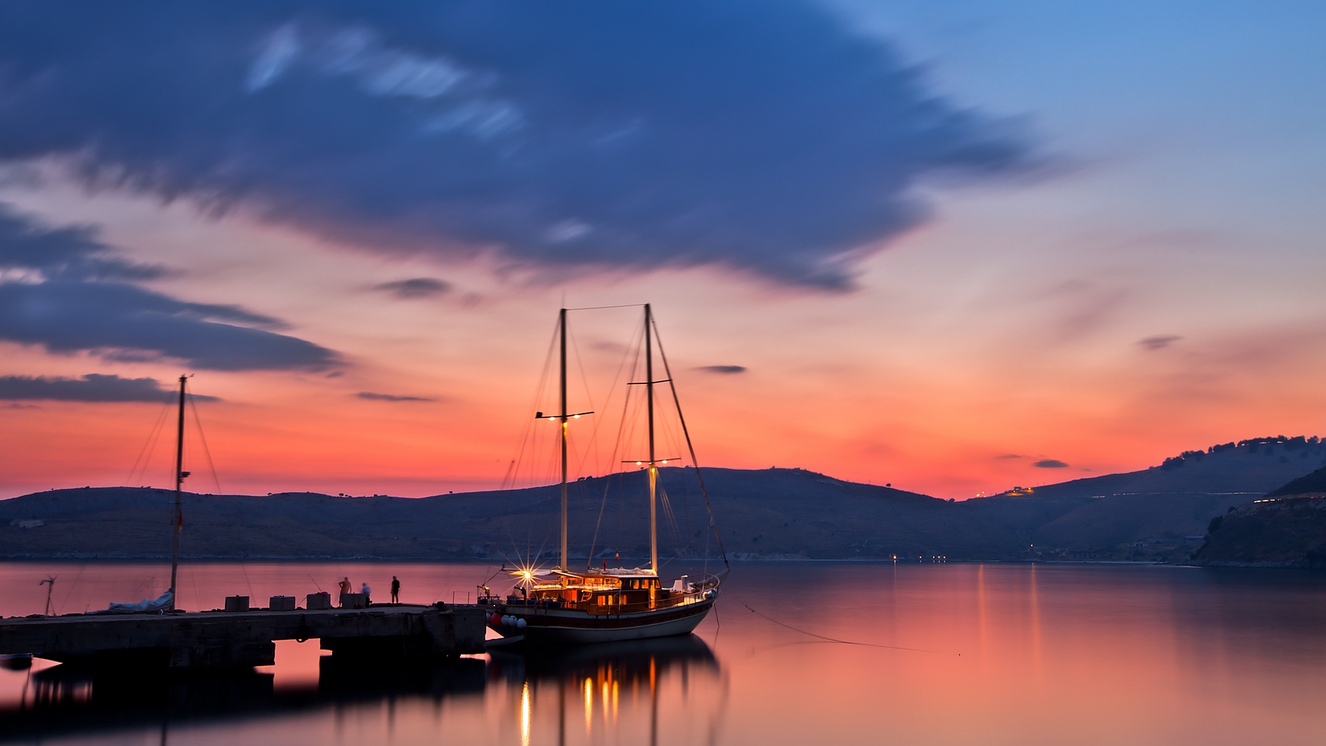 Sailboat docked at pier during sunset with colorful sky HD Wallpaper