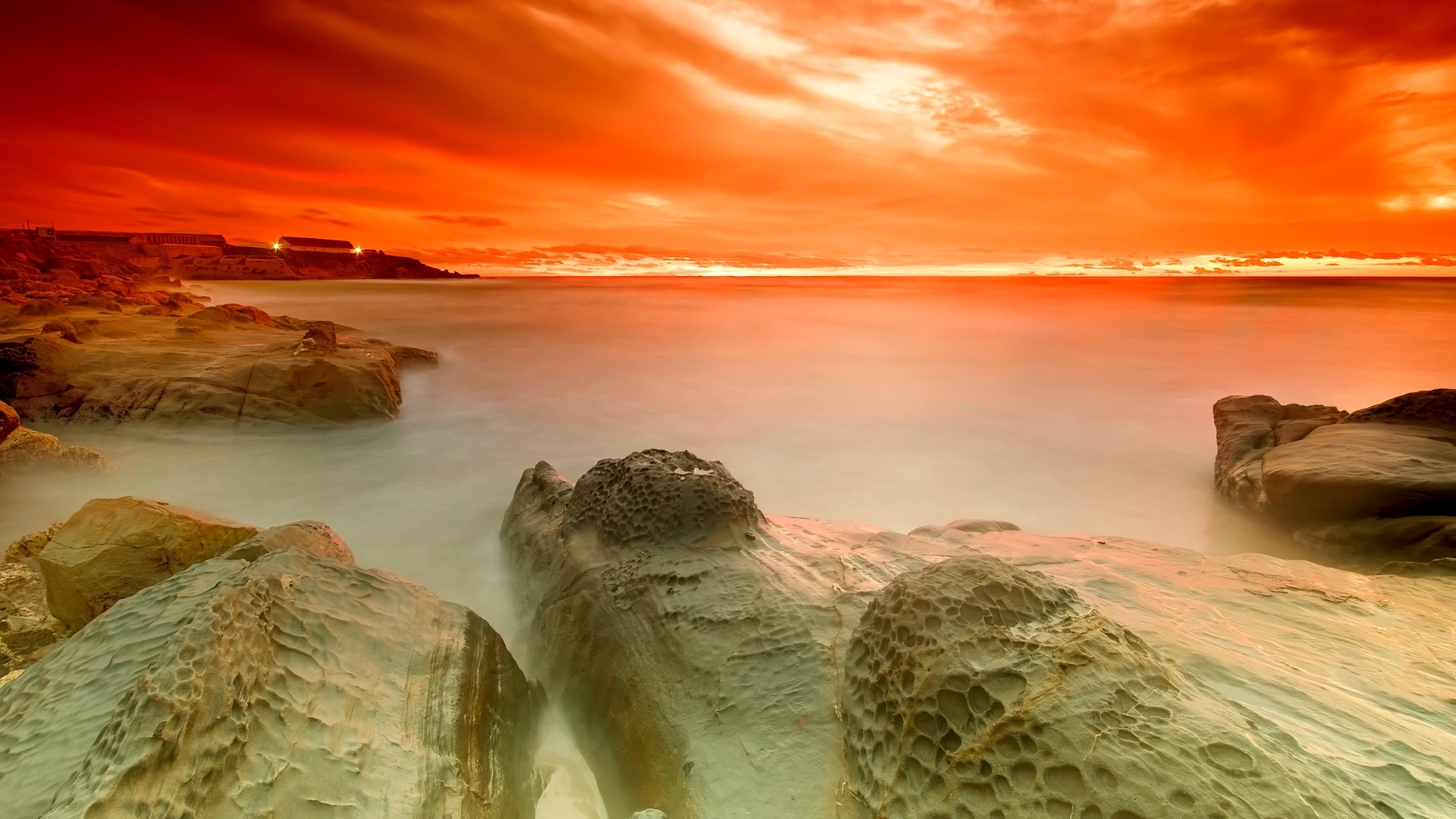 Orange sky over rocky coastline at sunset HD Wallpaper