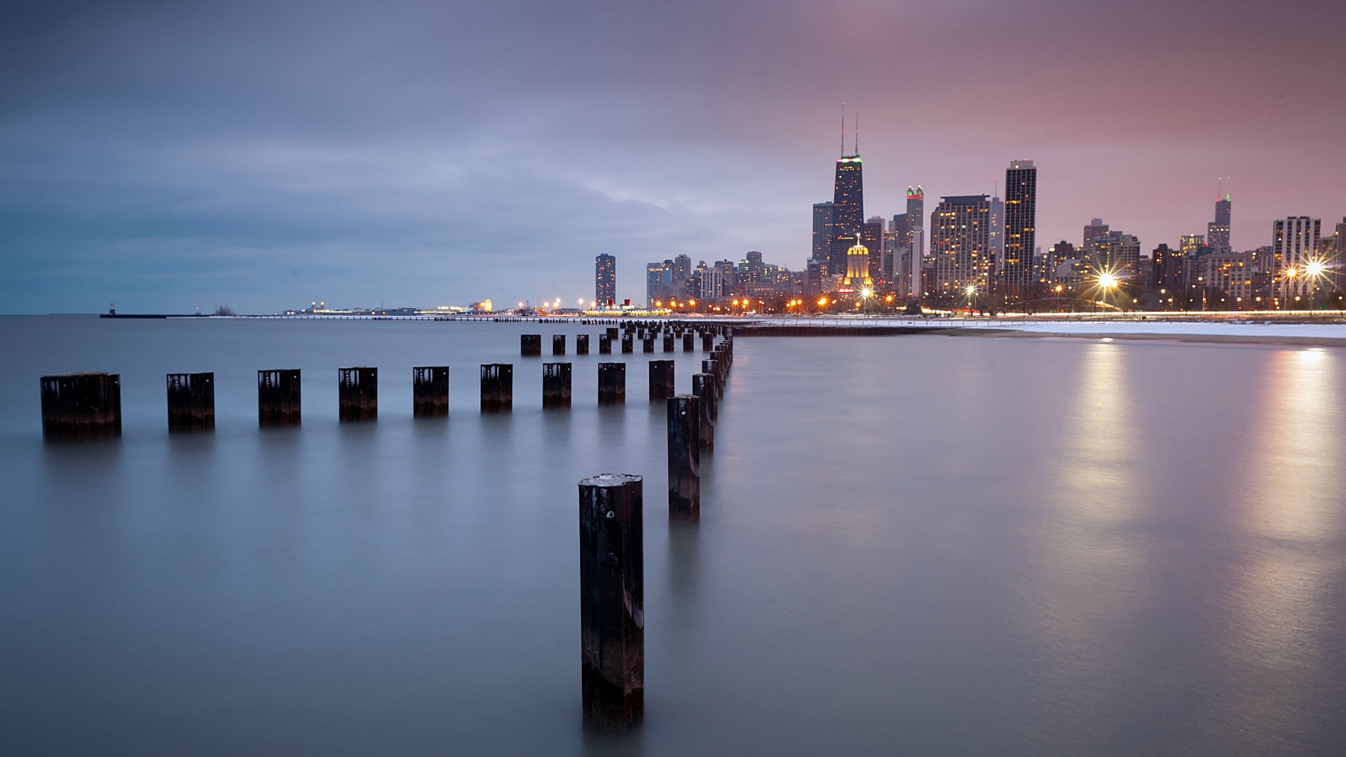 Chicago skyline with wooden posts in Lake Michigan at dusk HD Wallpaper