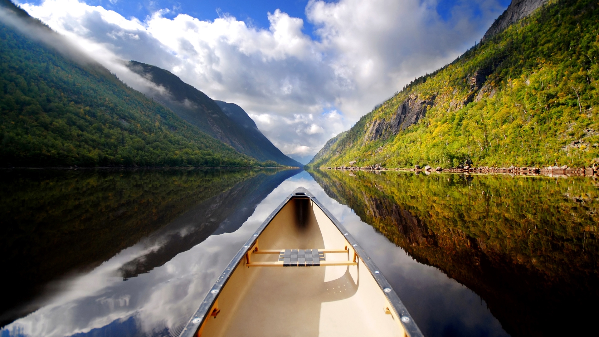 Canoe on a calm lake between mountains HD Wallpaper