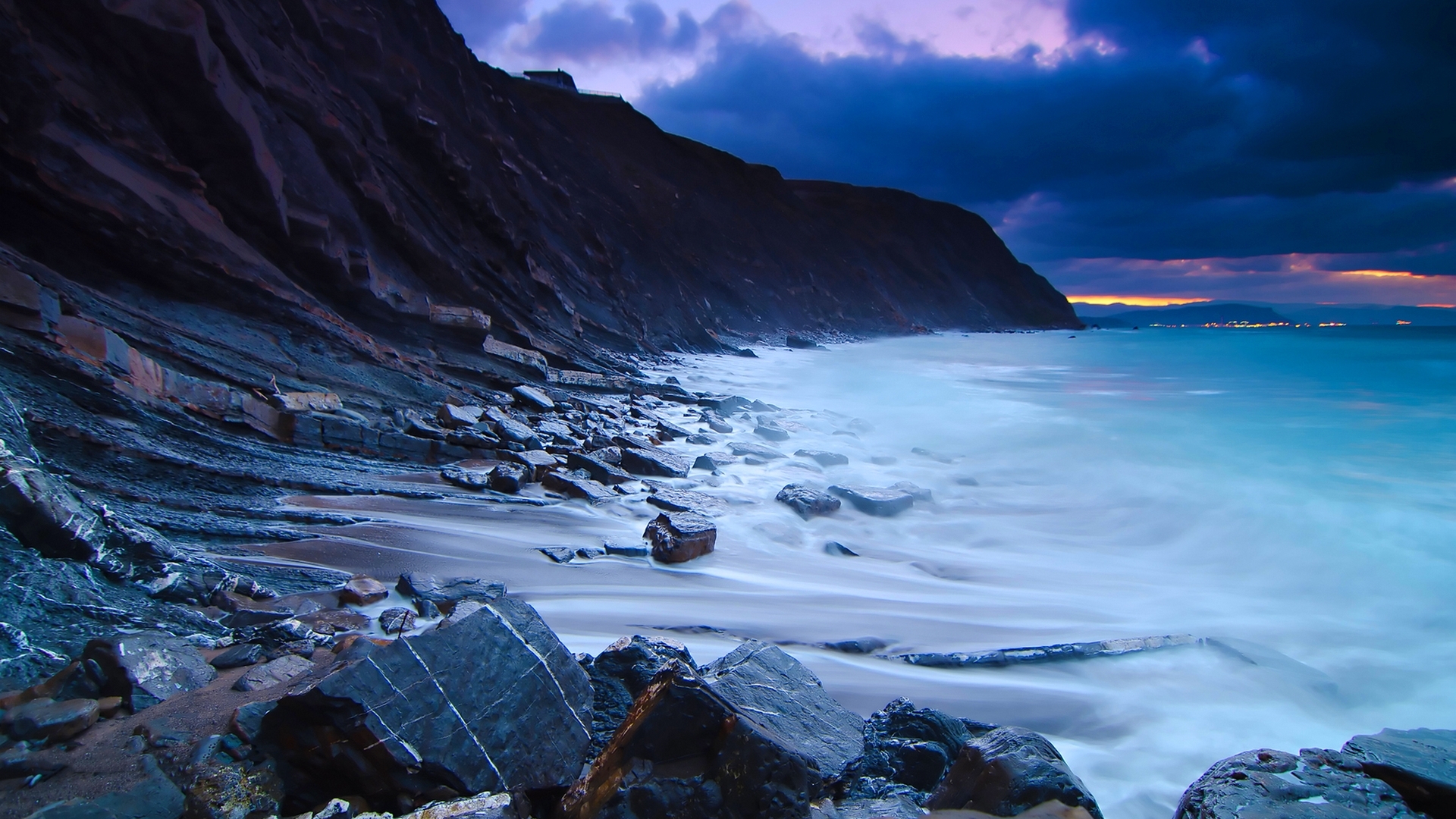 Rocky beach with waves at dusk HD Wallpaper