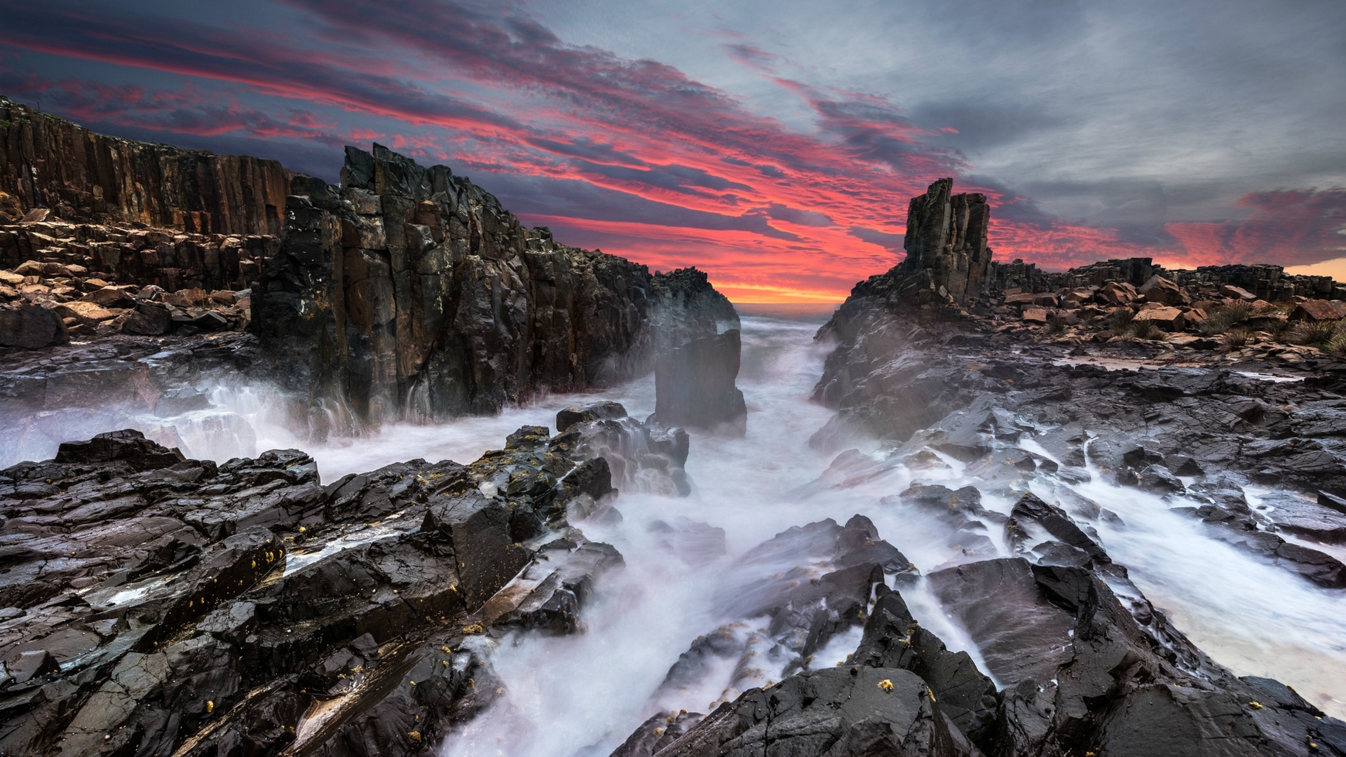 Rocky coastline with crashing waves at sunset in Australia HD Wallpaper