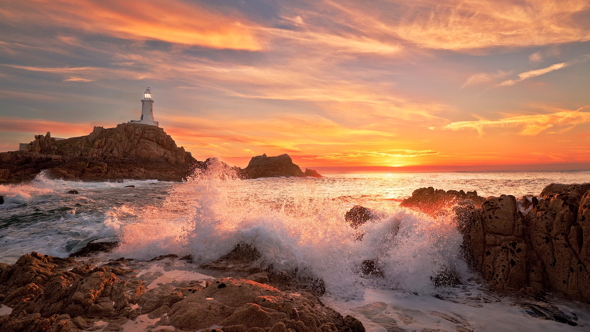 Corbiere Lighthouse at sunset with crashing waves HD Wallpaper