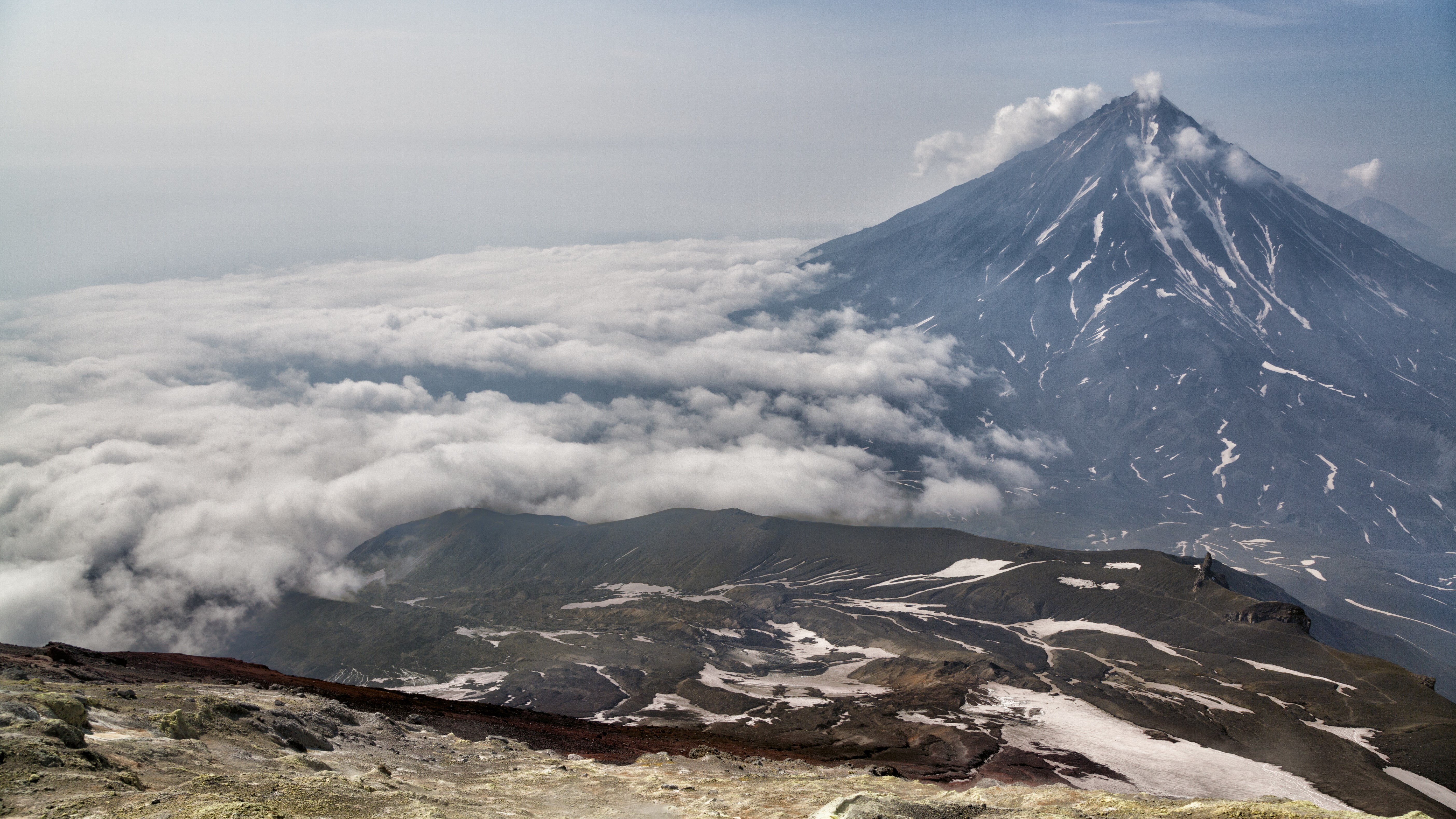 Volcano erupting above clouds HD Wallpaper