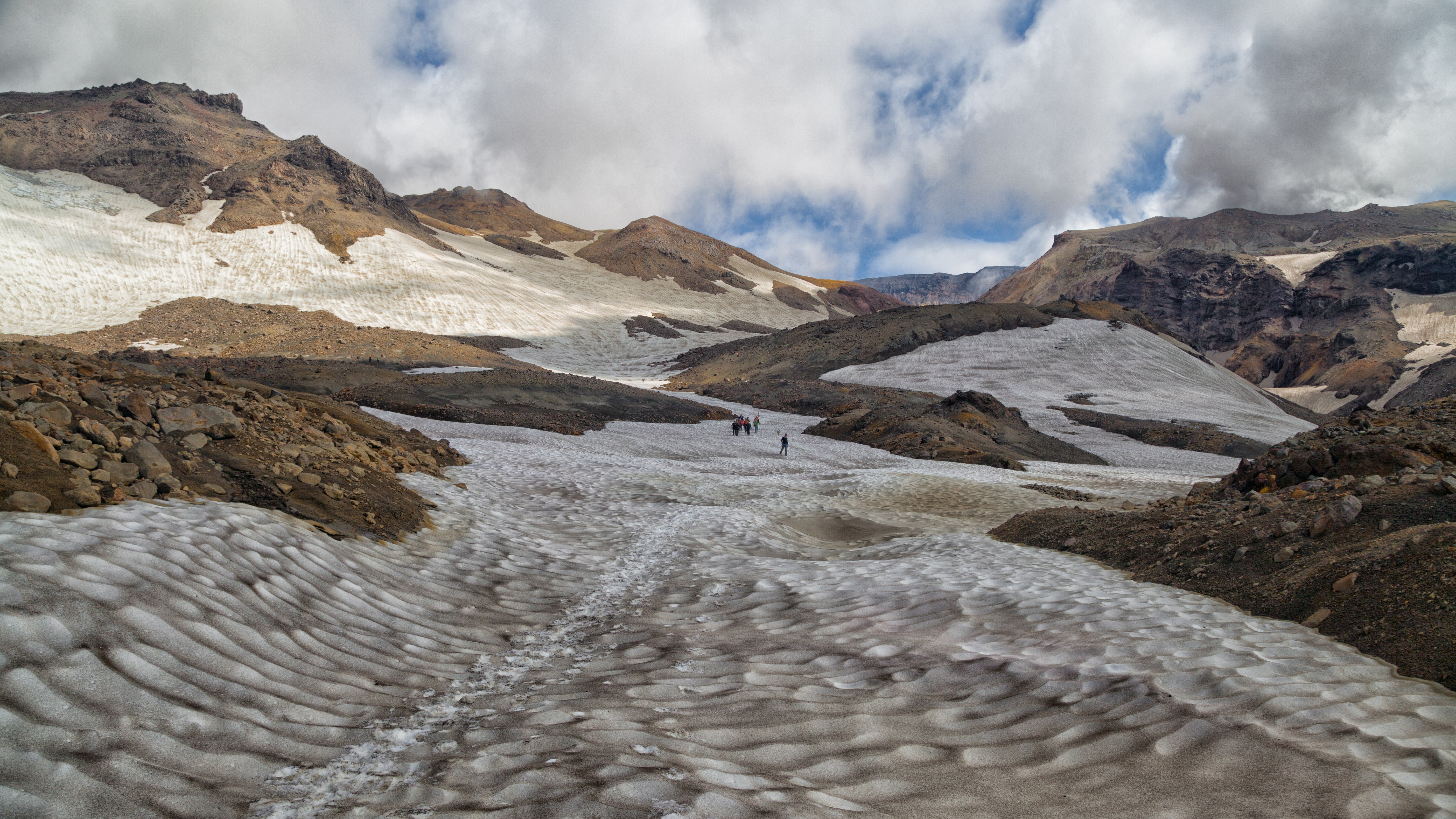 Hikers on a snow-covered mountain slope HD Wallpaper