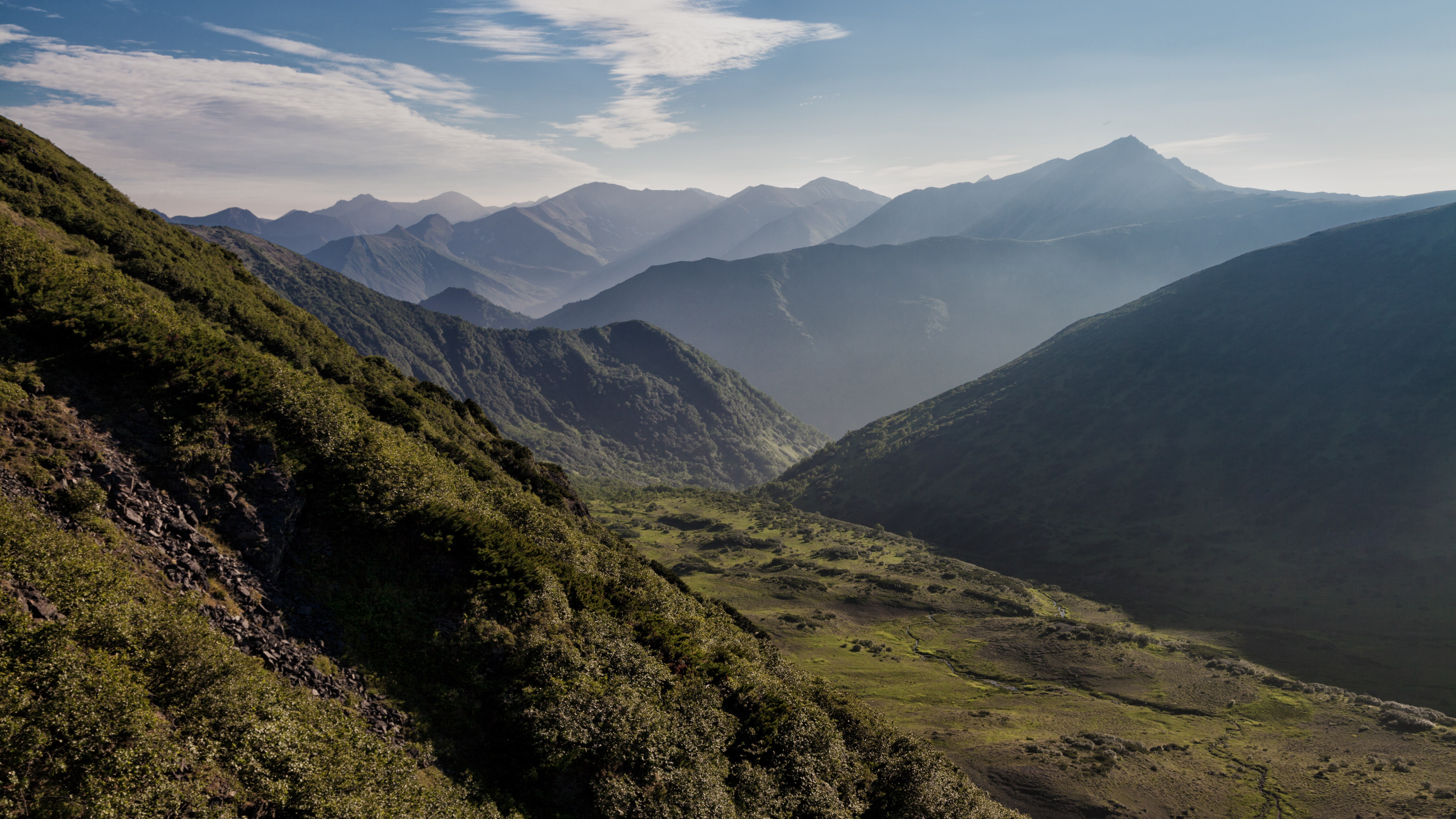 Misty mountain range with green slopes HD Wallpaper