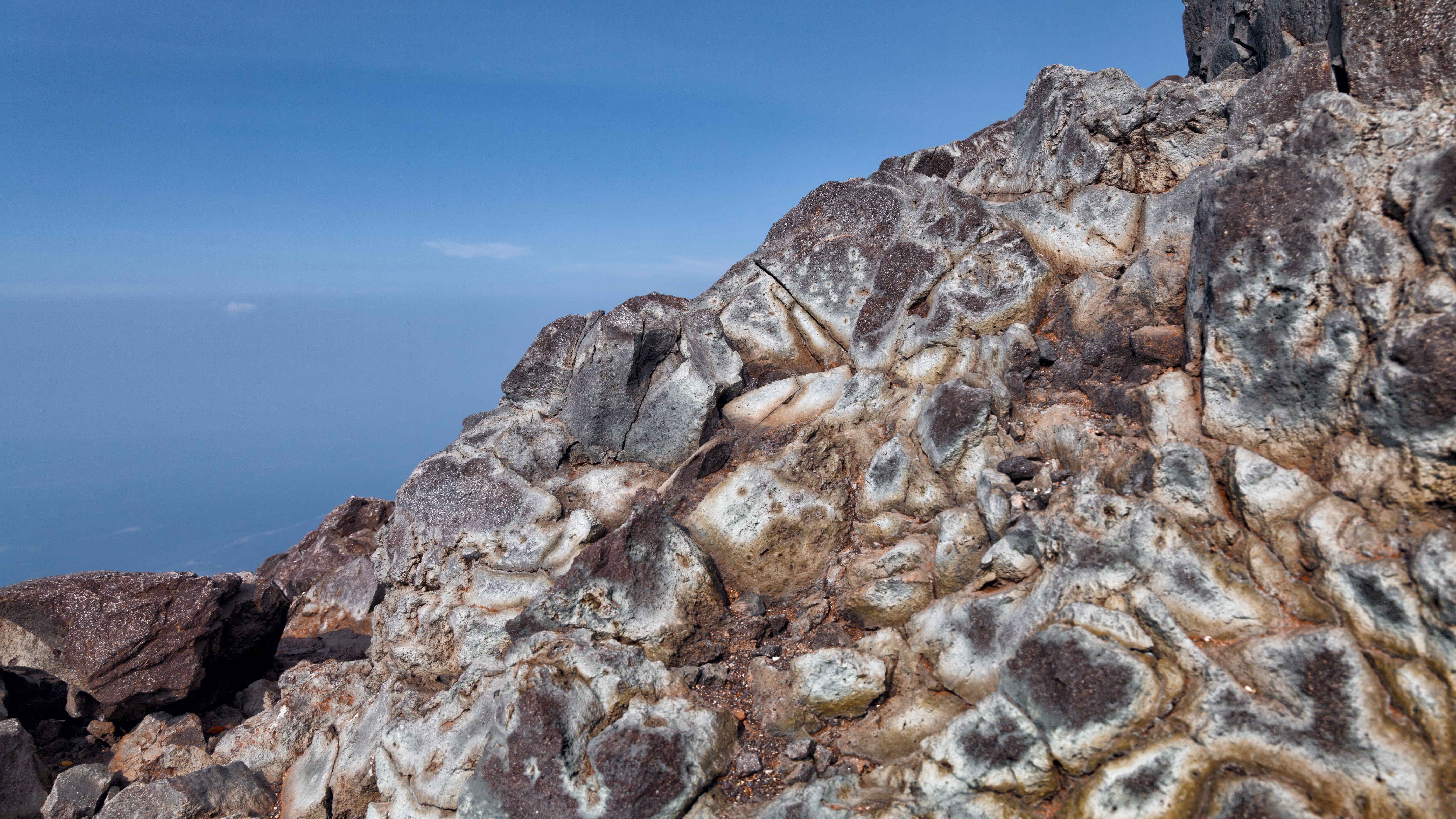 Rocky mountain slope overlooking the ocean HD Wallpaper