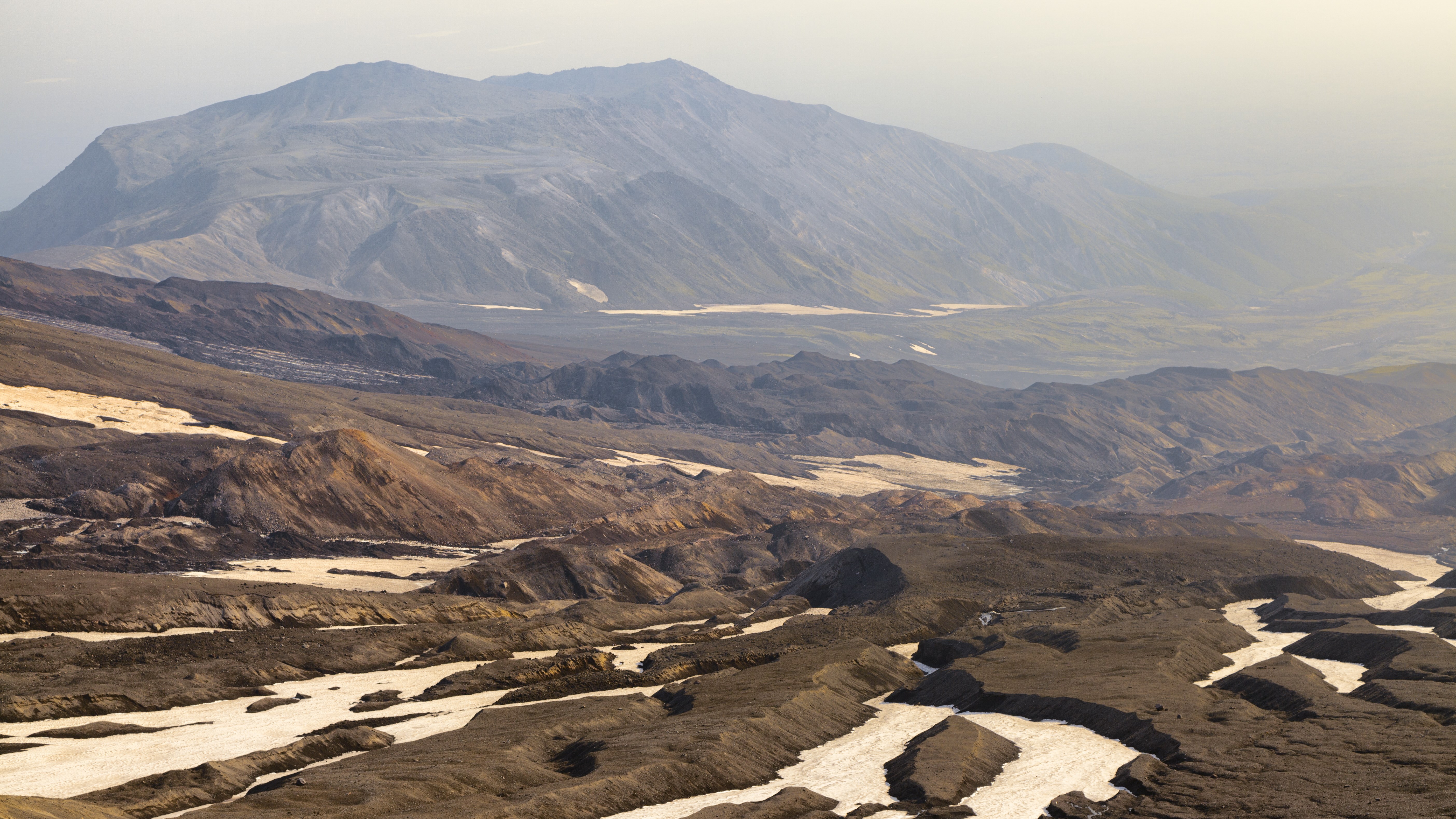 Volcanic landscape with mountains and snow patches HD Wallpaper