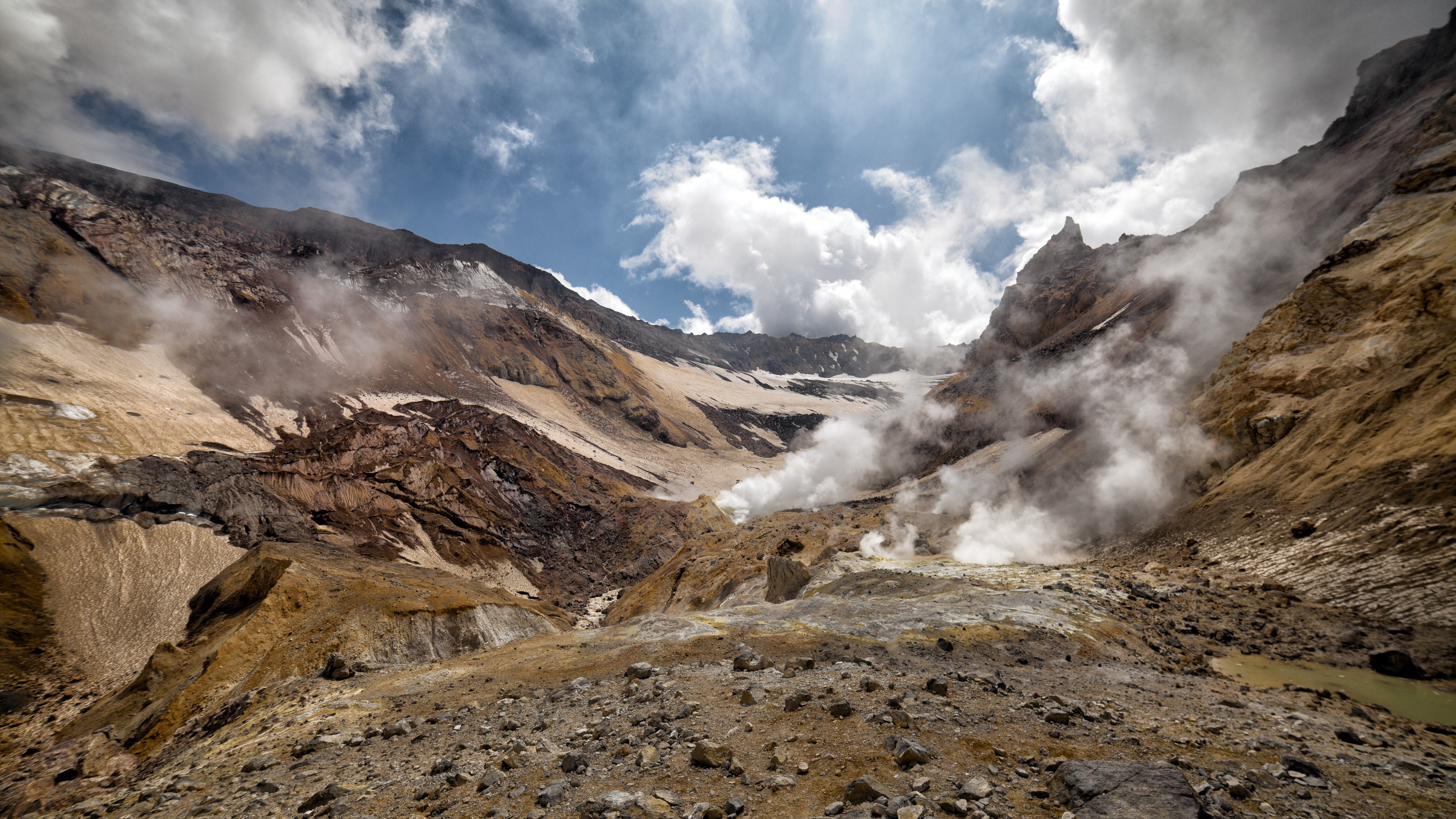 Volcanic landscape with steam vents and clouds HD Wallpaper