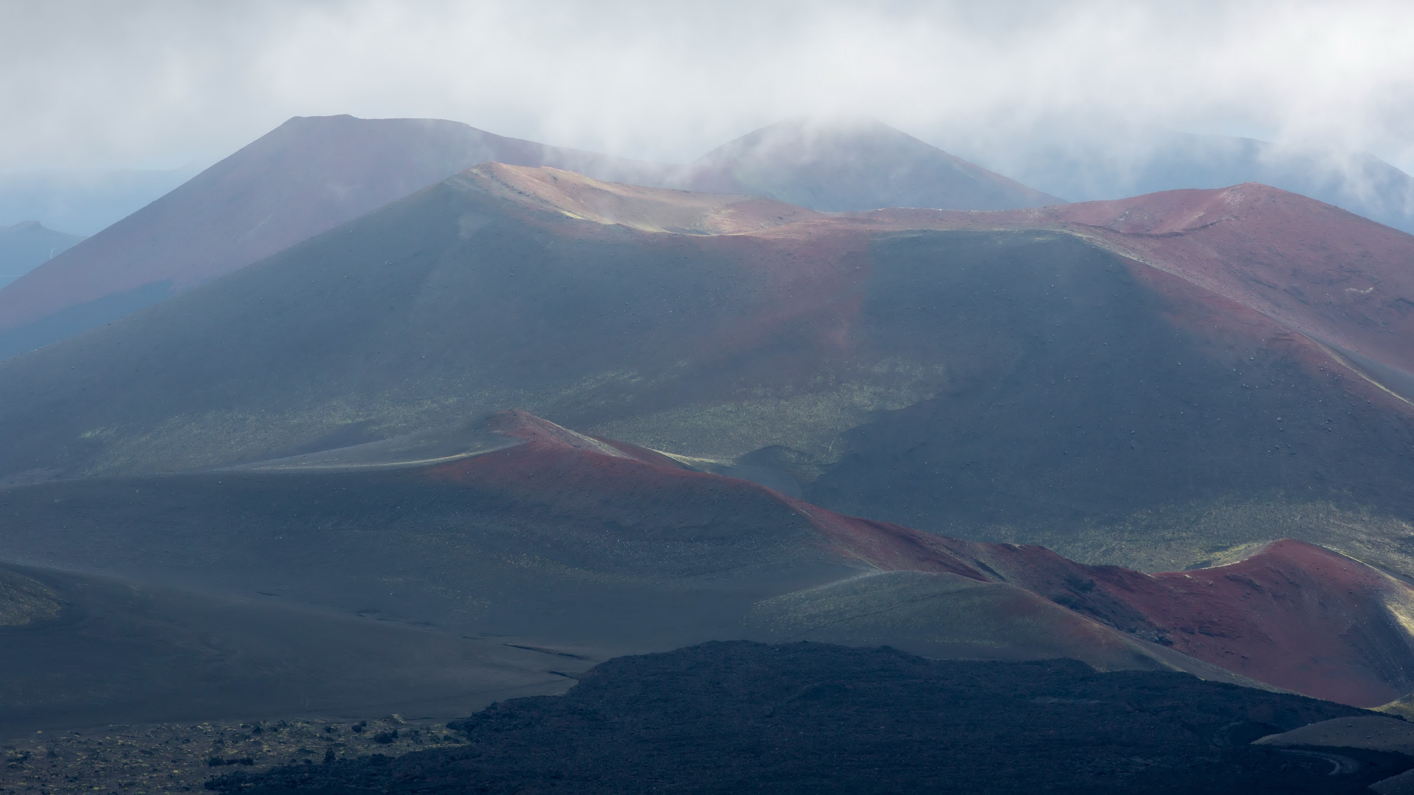 Volcanic landscape with craters and lava fields HD Wallpaper