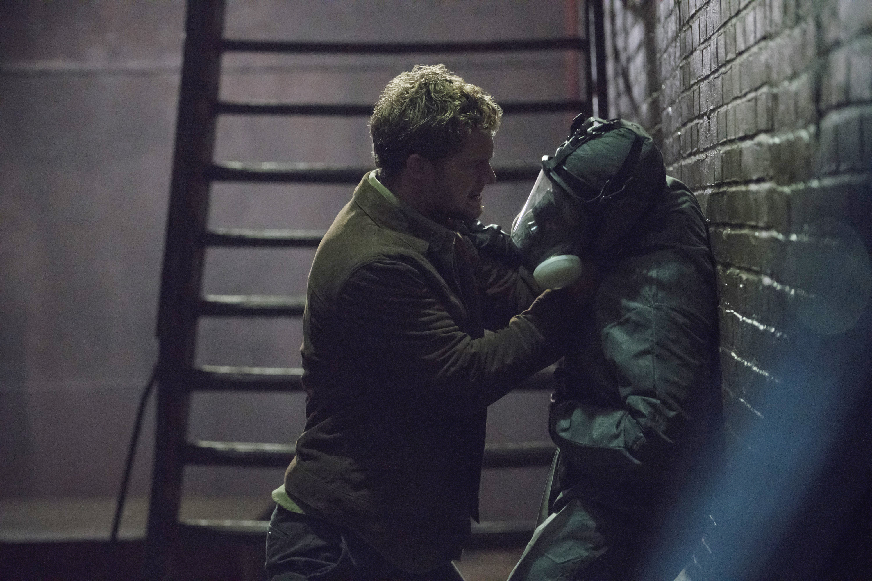Iron Fist fighting a person in a gas mask HD Wallpaper