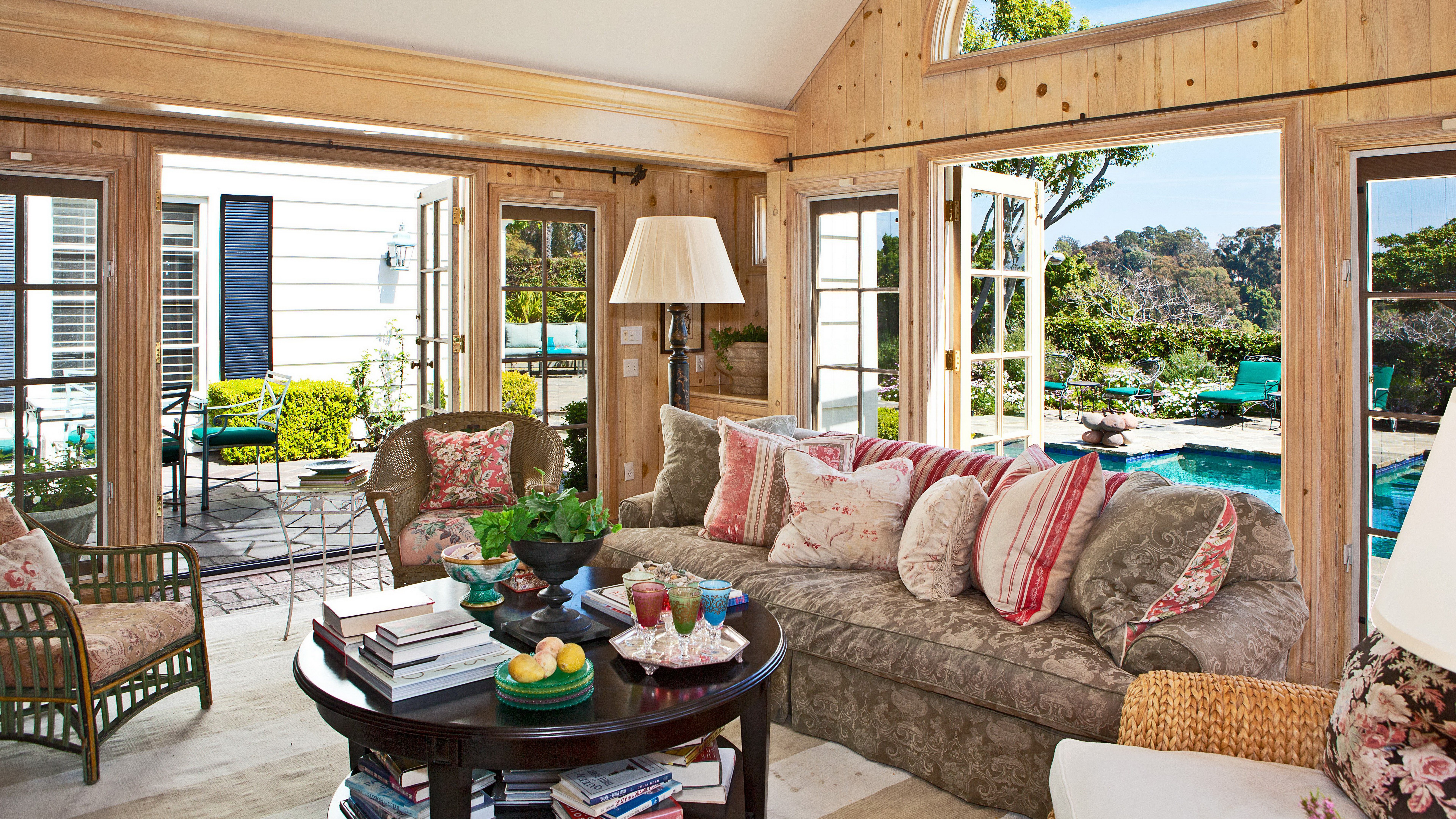 Living room with French doors opening to a pool and garden HD Wallpaper