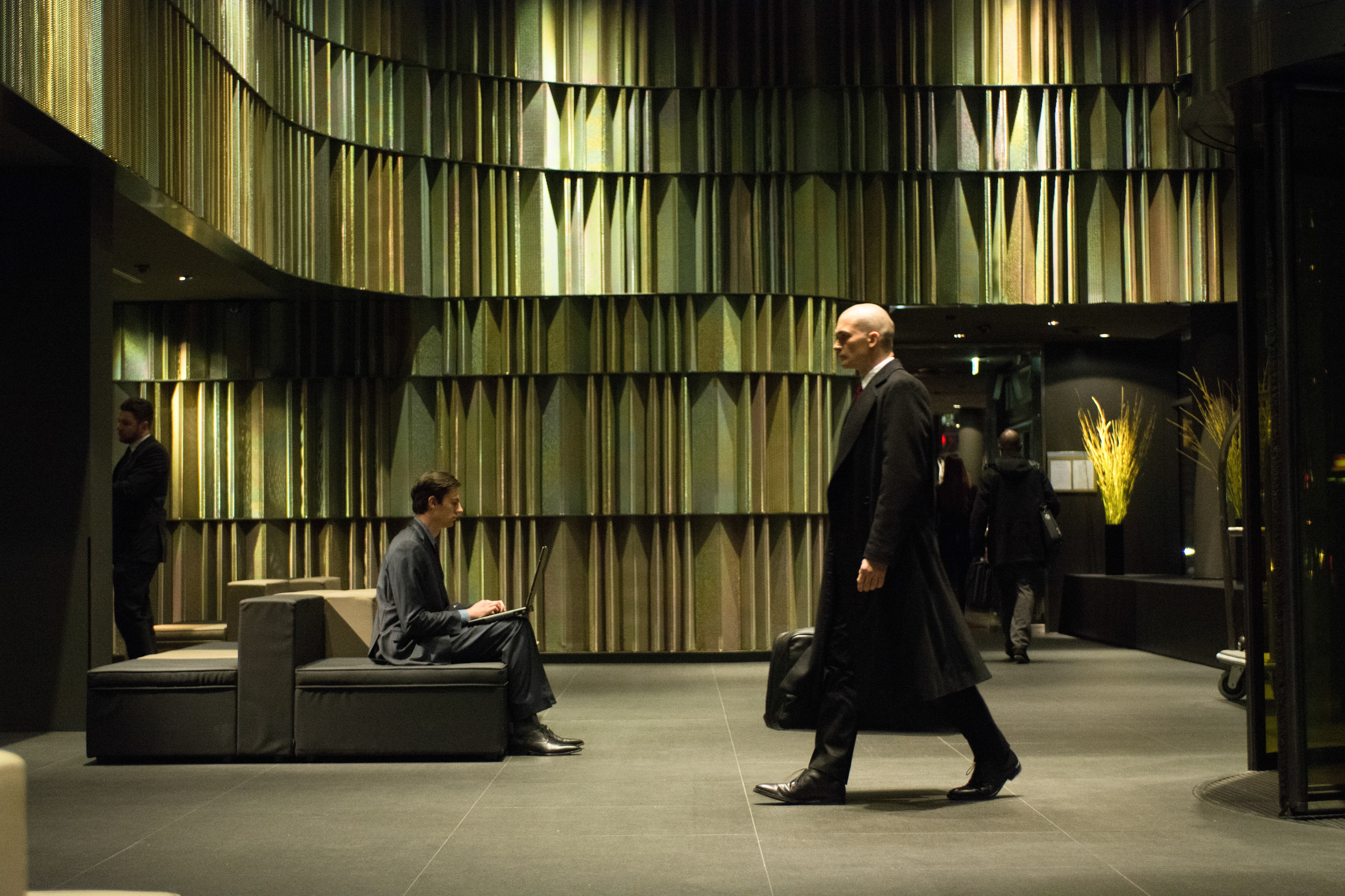 Agent 47 in a modern lobby HD Wallpaper
