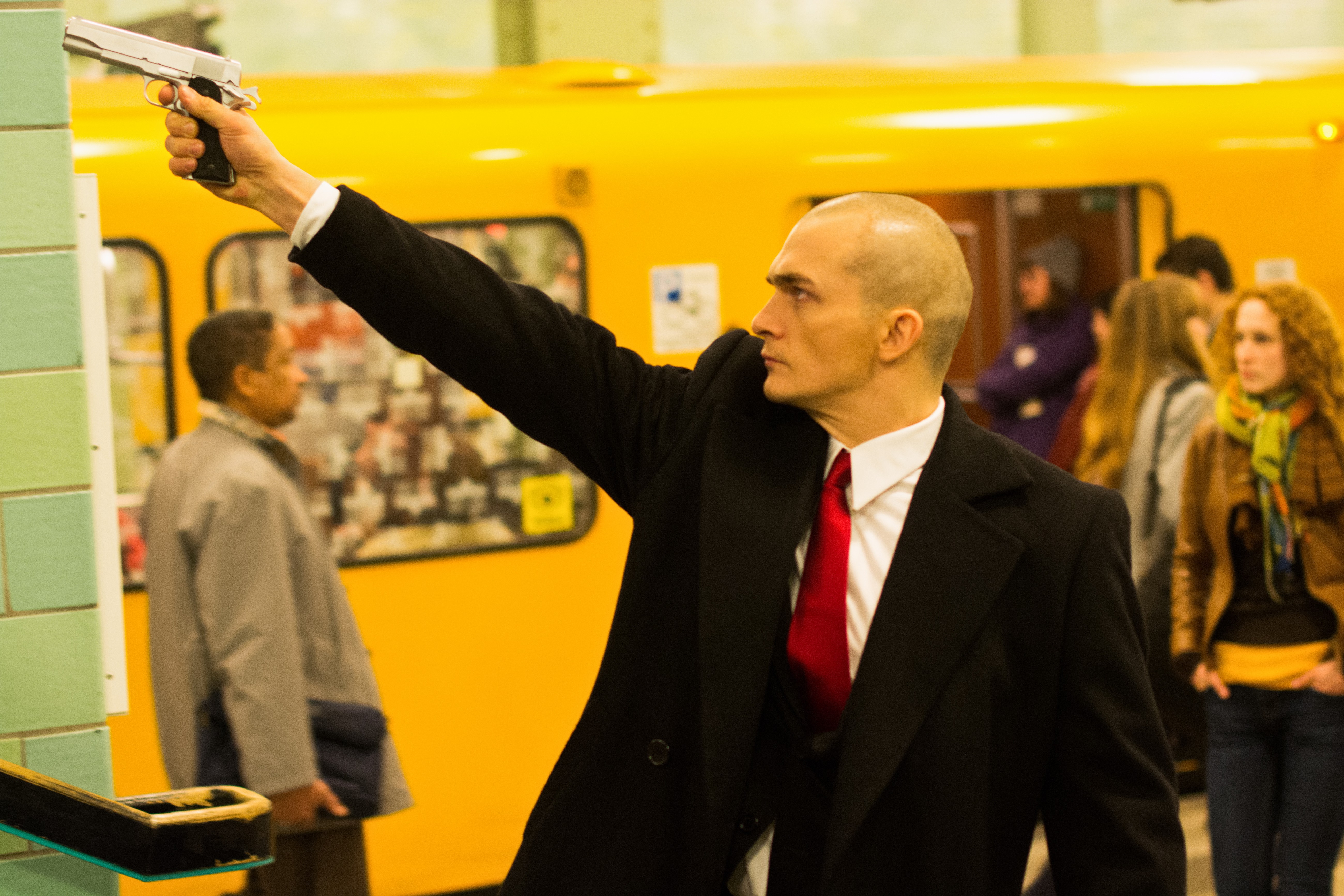 Agent 47 with a gun in a subway station HD Wallpaper